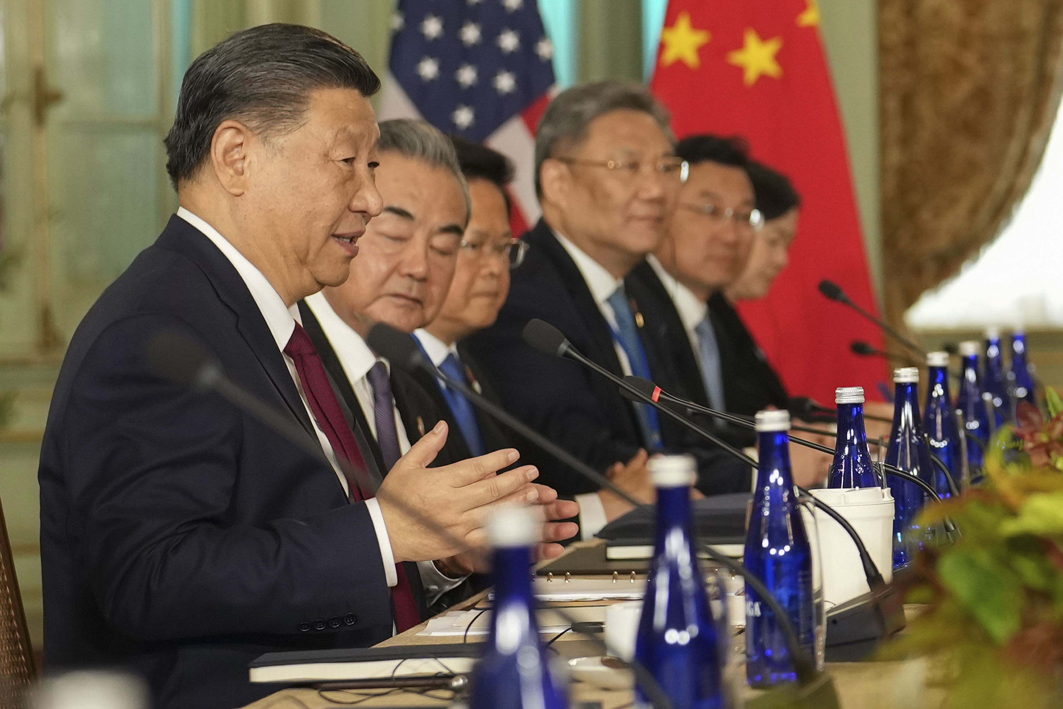 A row of people including China's President President Xi Jinping looks off screen.
