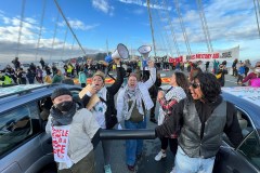 A group of protesters, some holding bullhorns scream in the center of the Bay Bridge during a large protest that has disrupting traffic.