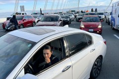 A person in a car looks on in the direction of a protest while on gridlock traffic during a protest on the Bay Bridge.