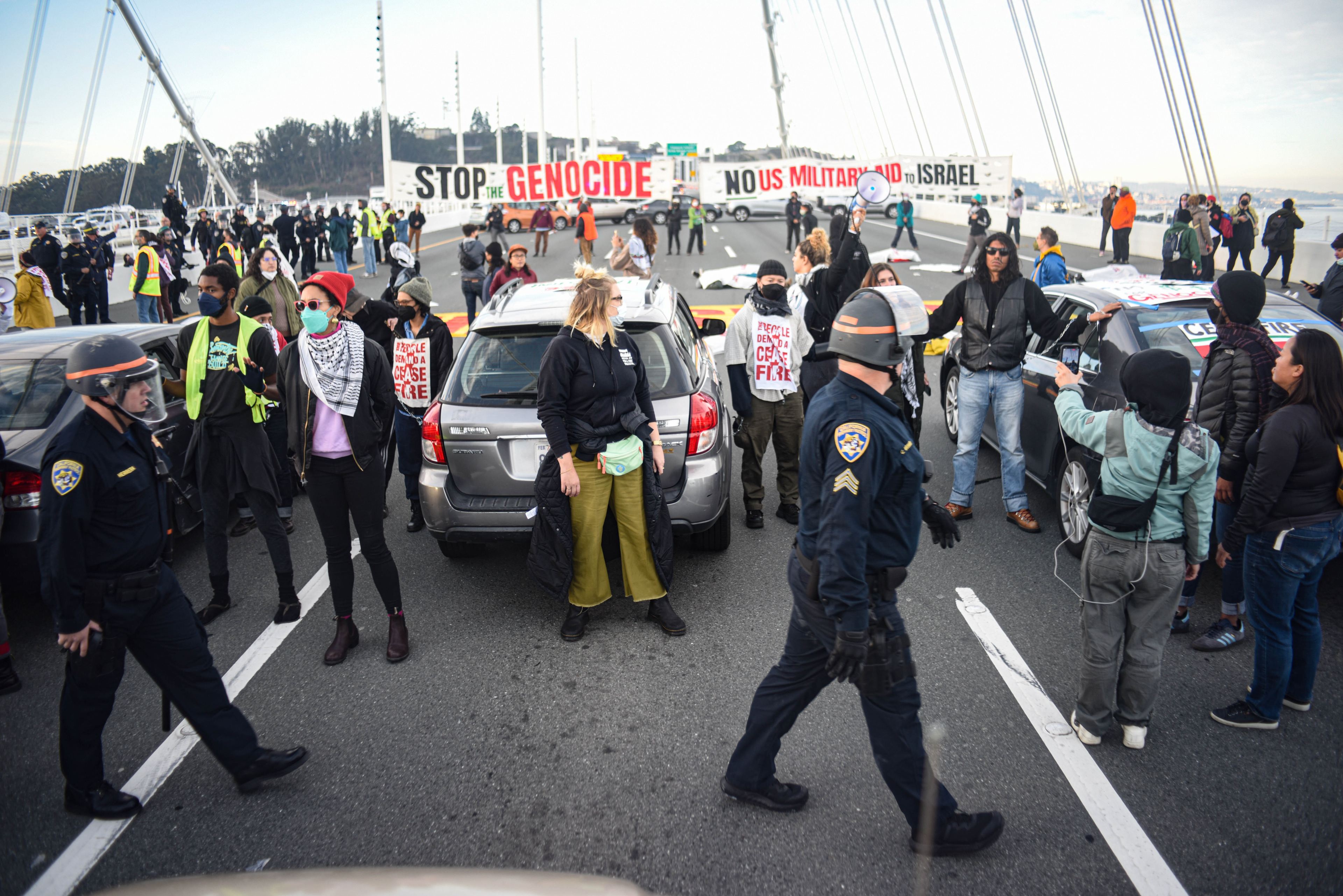 California Highway Patrol officers walk among protestors during a demonstration which blocked traffic on the Bay Bridge for hours on Nov. 16, 2023.