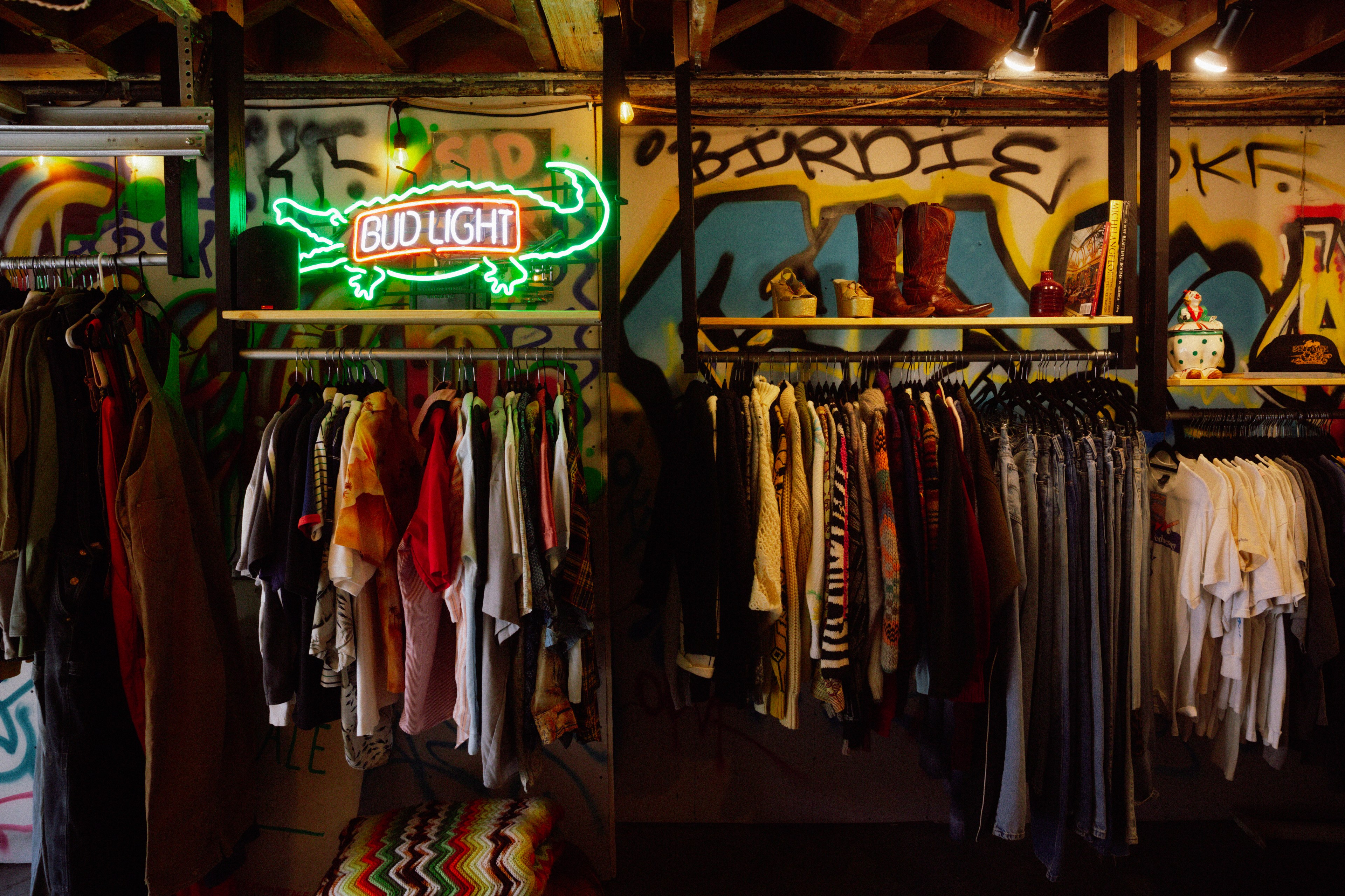 Racks of clothes hang inside Sensitive Vintage, which is decorated with graffiti and a neon alligator sign gifted to the pop-up by Burning Man co-founder and artist John Law. 