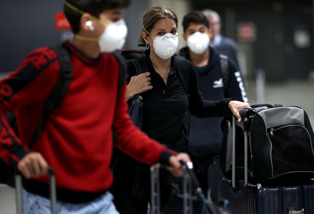 three people are seen wearing face masks