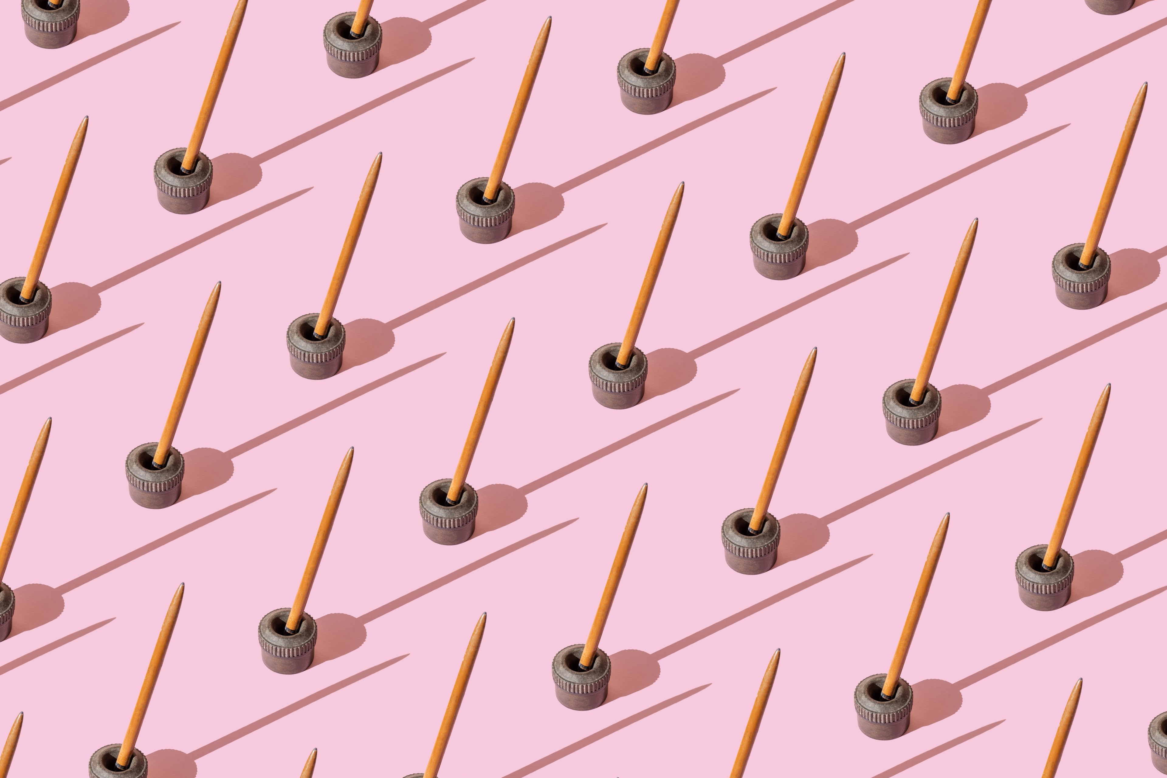 An illustration of repeated old, antique ink pen on the pink background
