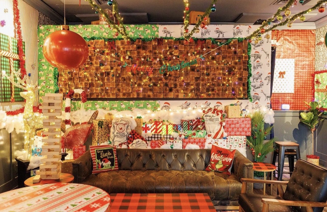 Wrapped presents are piled on top of leather couch in a bar lounge. 