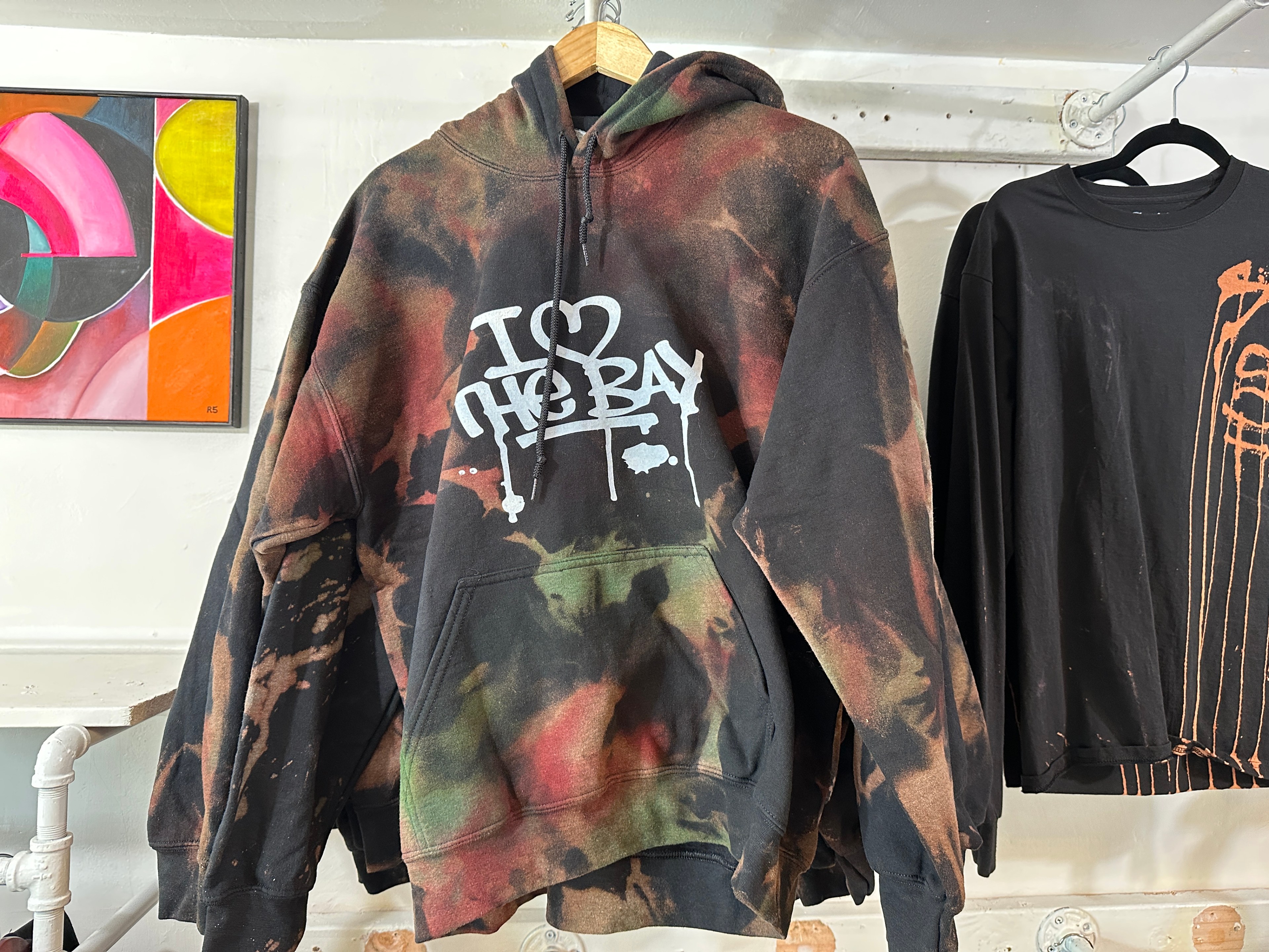 A hoodie with &quot;I Love the Bay&quot; graffiti lettering hangs in an art and apparel shop on Valencia Street in San Francisco.