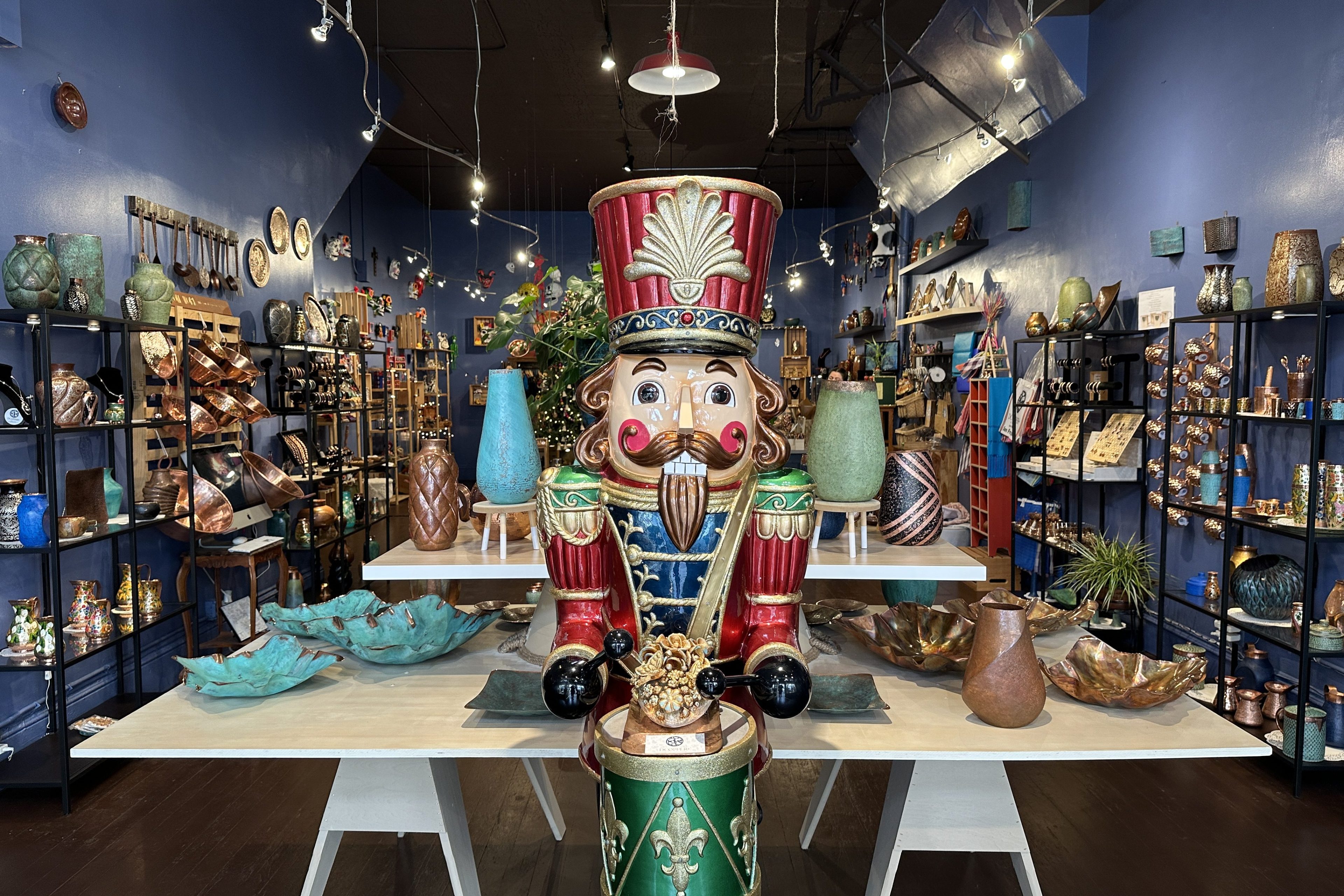 A giant Nutcracker statue stands at the entrance of a shop, which sells artisan-crafted copper vases, bowls and plates from Mexico.