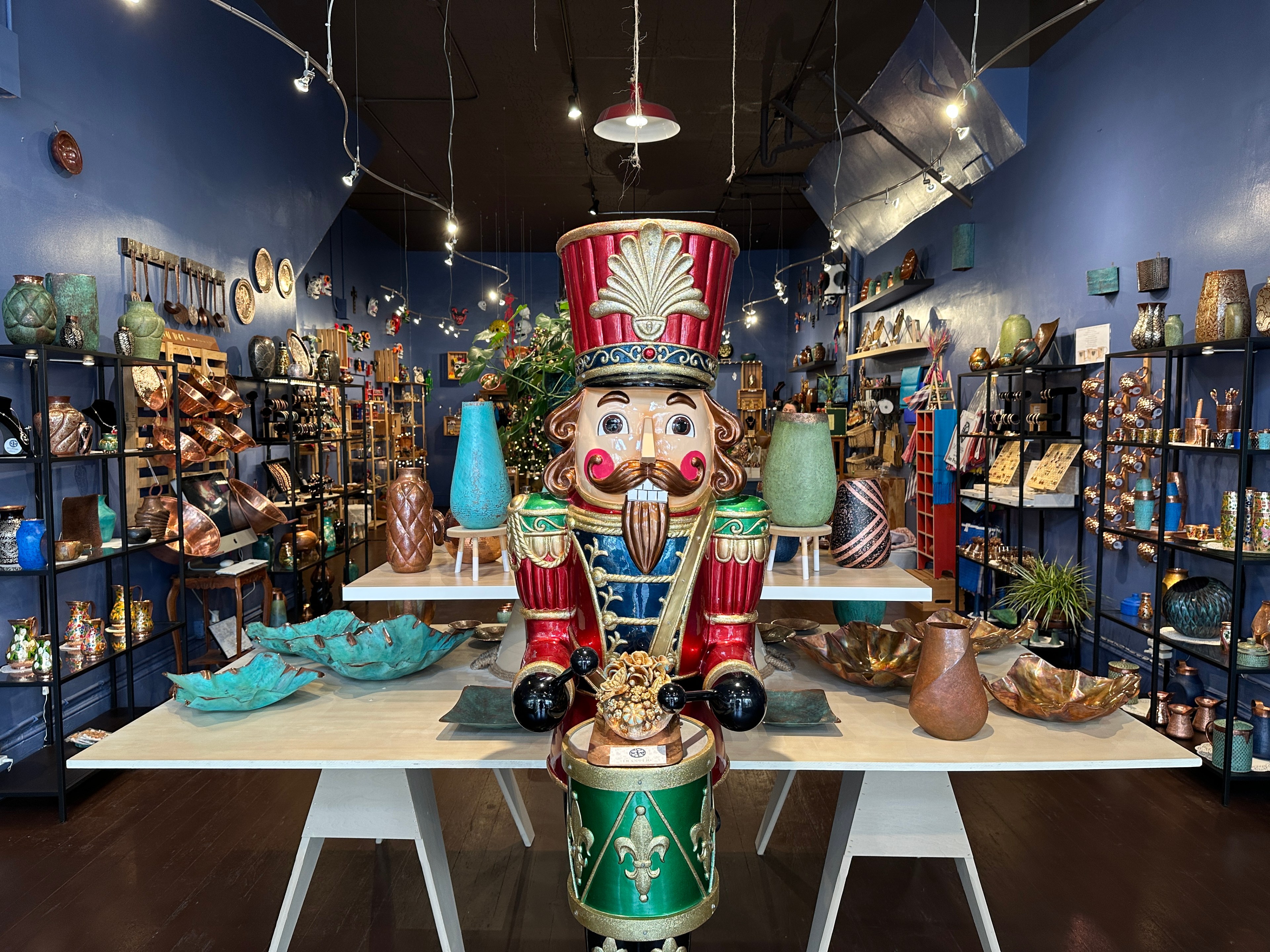 A giant Nutcracker statue stands at the entrance of a shop, which sells artisan-crafted copper vases, bowls and plates from Mexico.