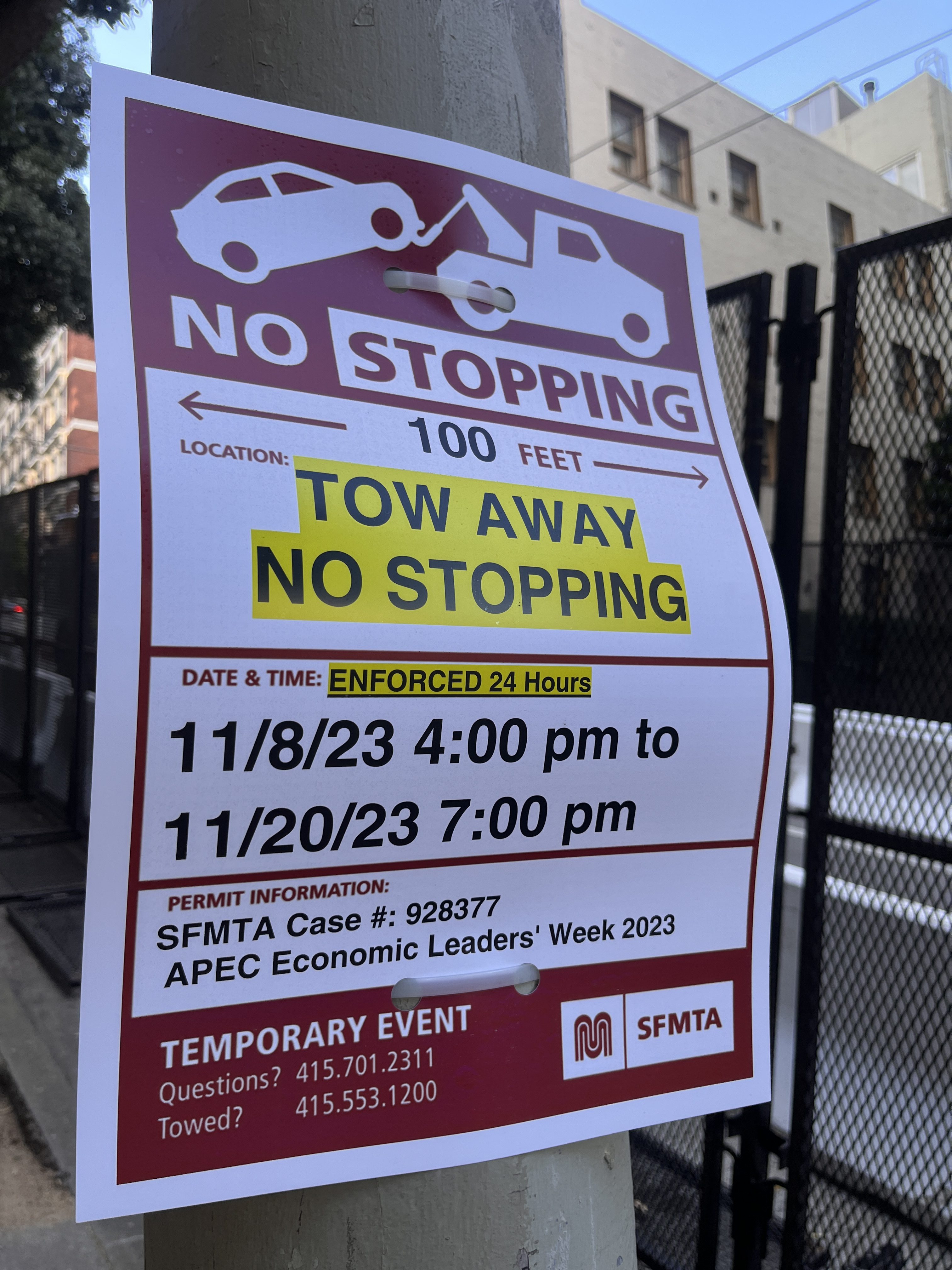 A red and white sign on a lamppost warns of no parking during APEC in San Francisco.