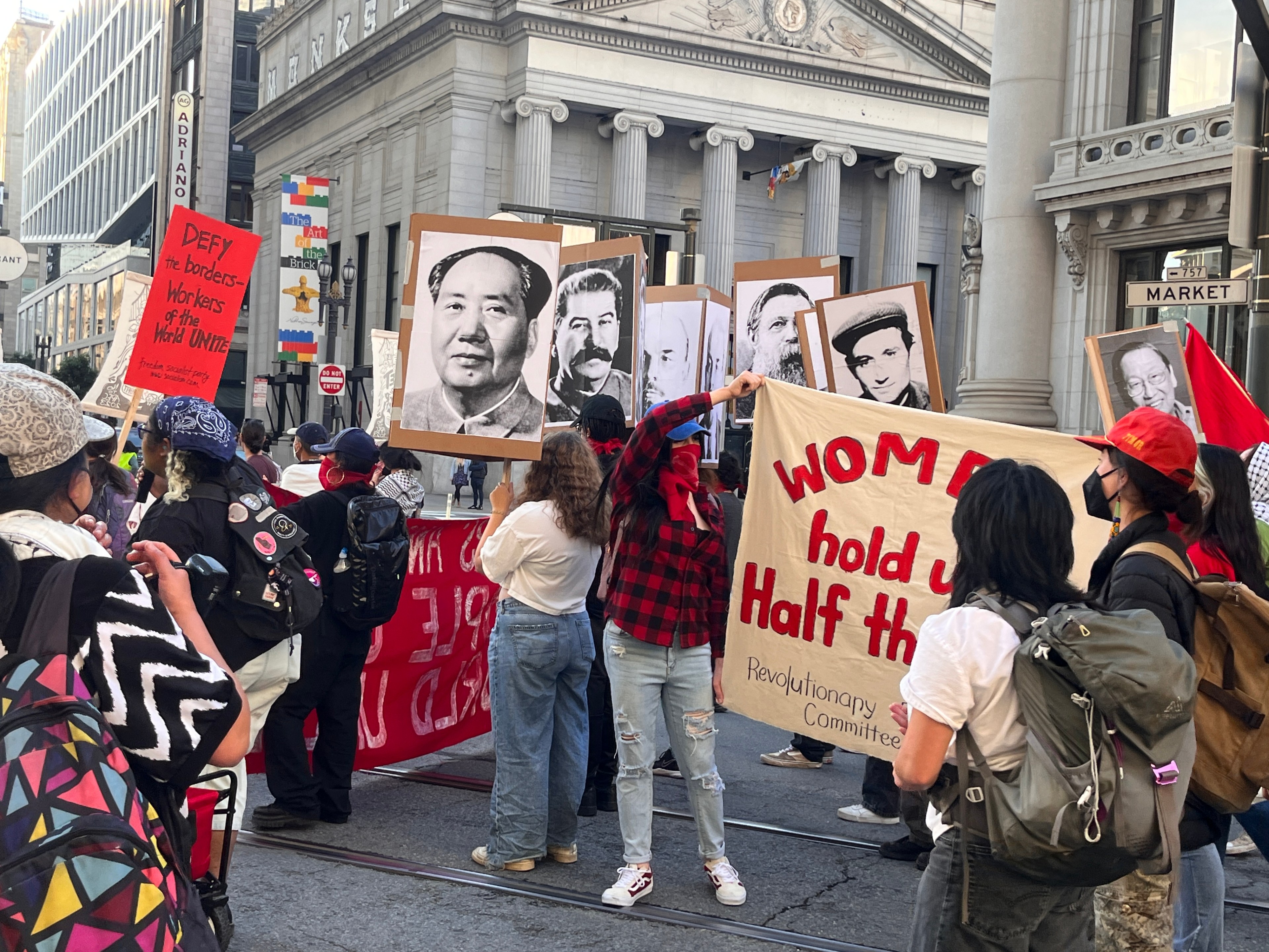Protesters hold signs, banners and pictures of Mao Tse-tung, Marx and Lenin.
