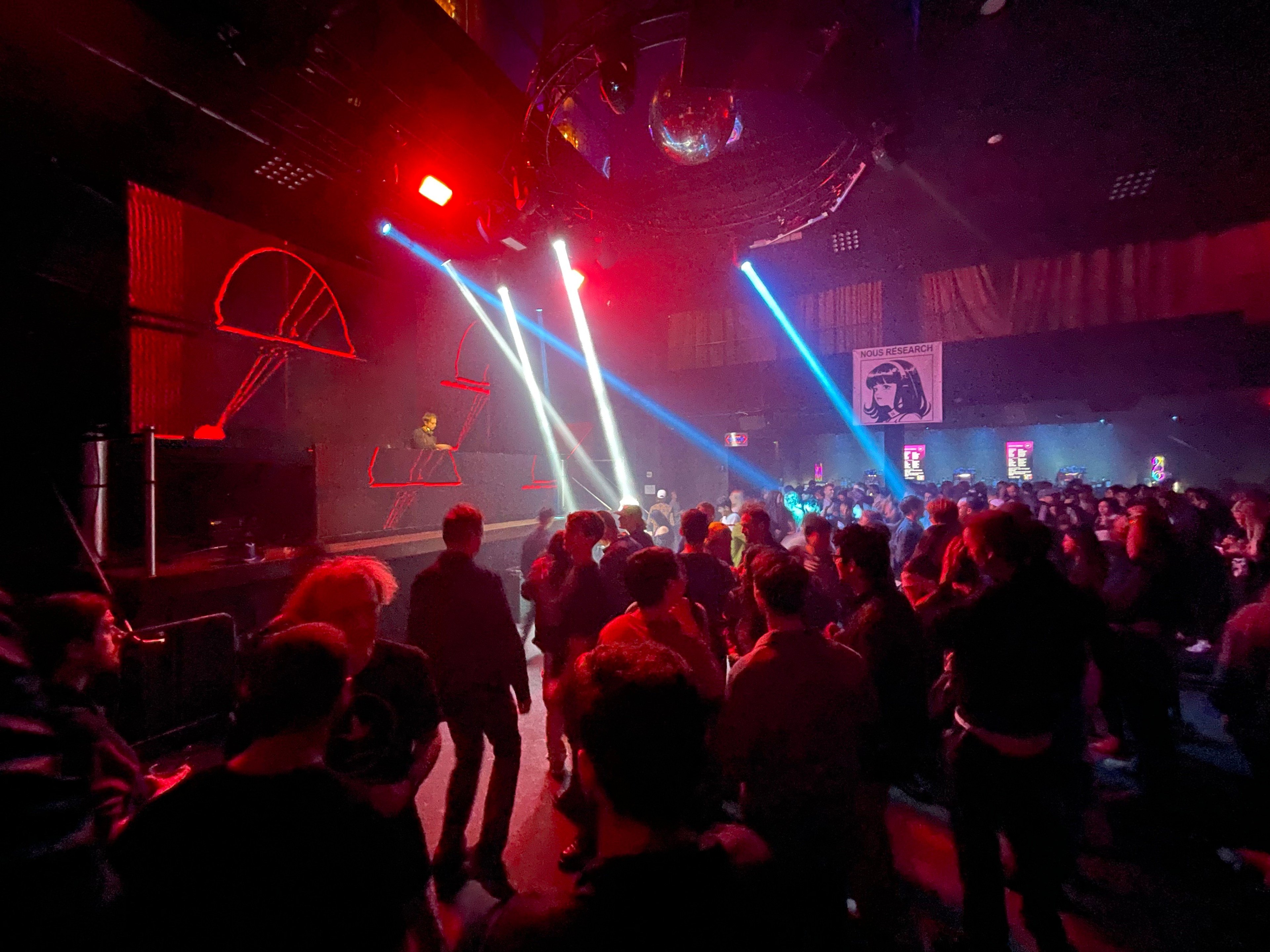 People party inside a dark nightclub.