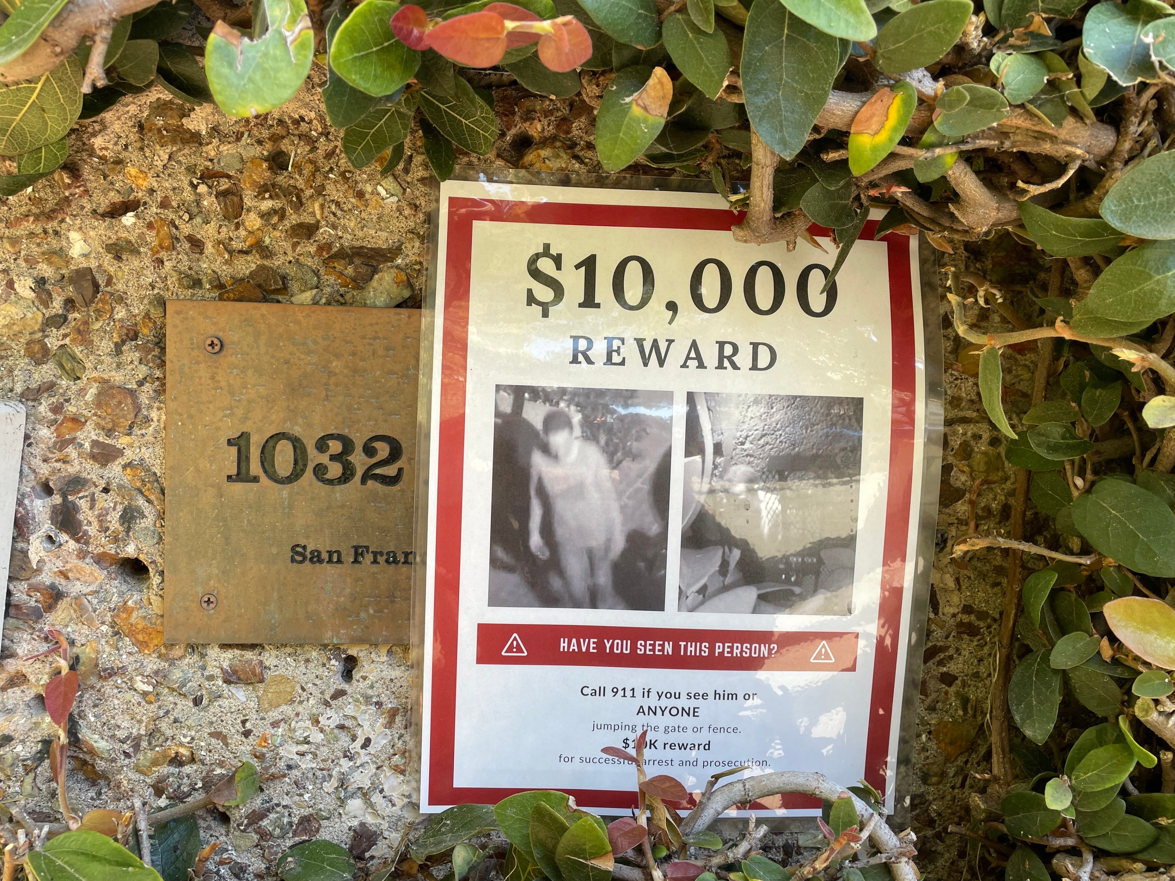A mansion's entrance with a poster offering a $10,000 reward is seen in an upscale San Francisco neighborhood.