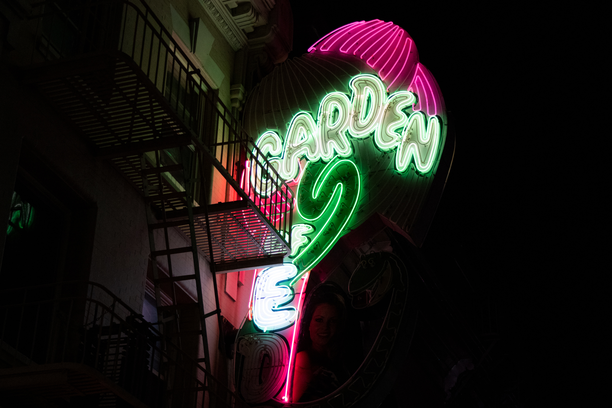 A neon sign at night with the words &quot;GARDEN OF E..&quot;