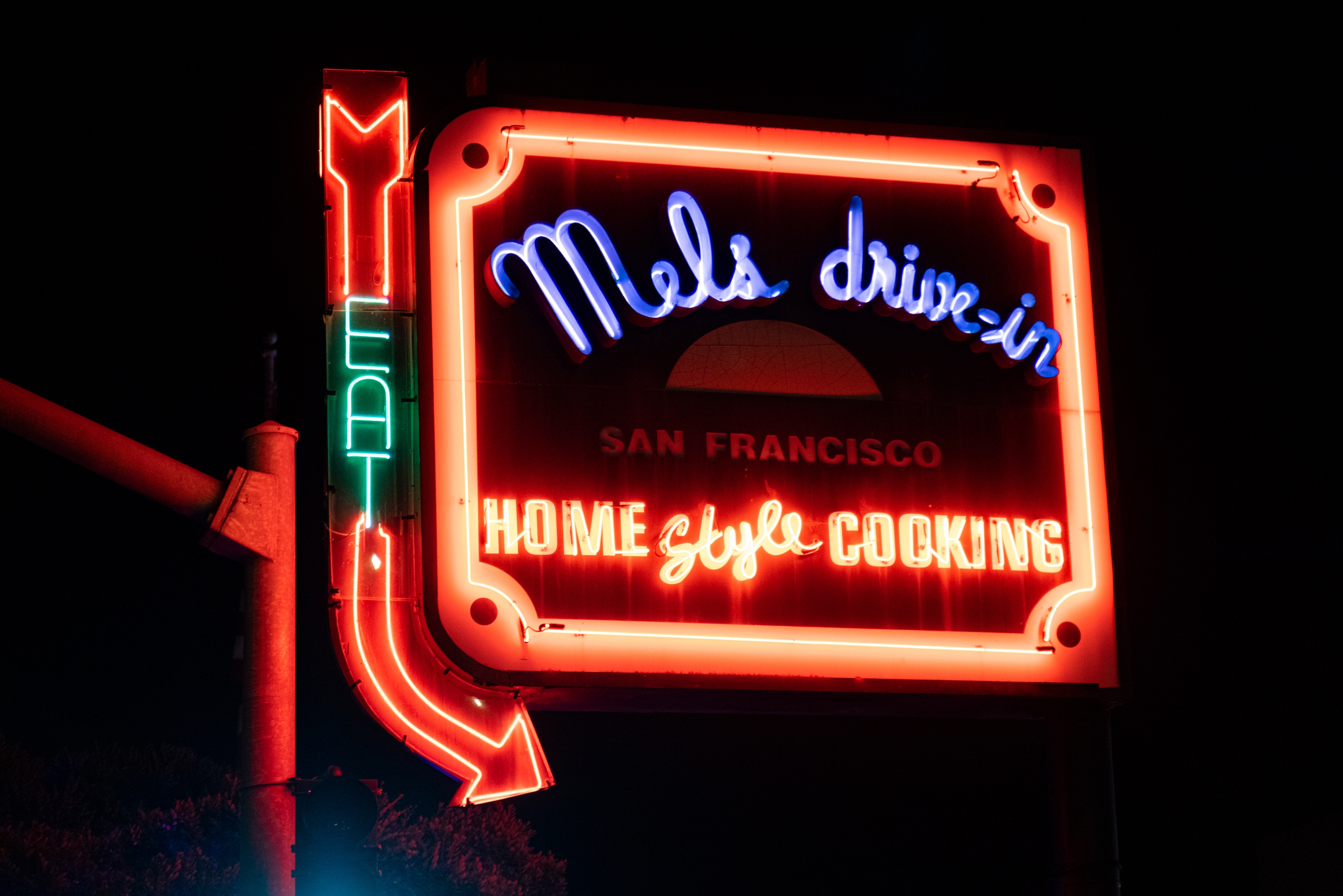 A multicolored neon sign that reads &quot;Mel's Drive-In Home Style Cooking&quot;