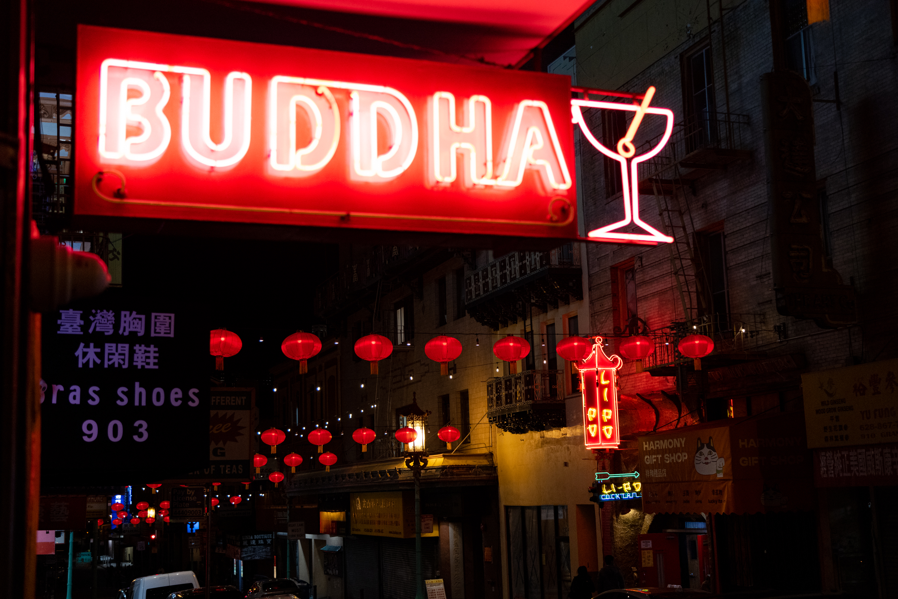 A red neon sign at night that reads &quot;BUDDHA&quot;