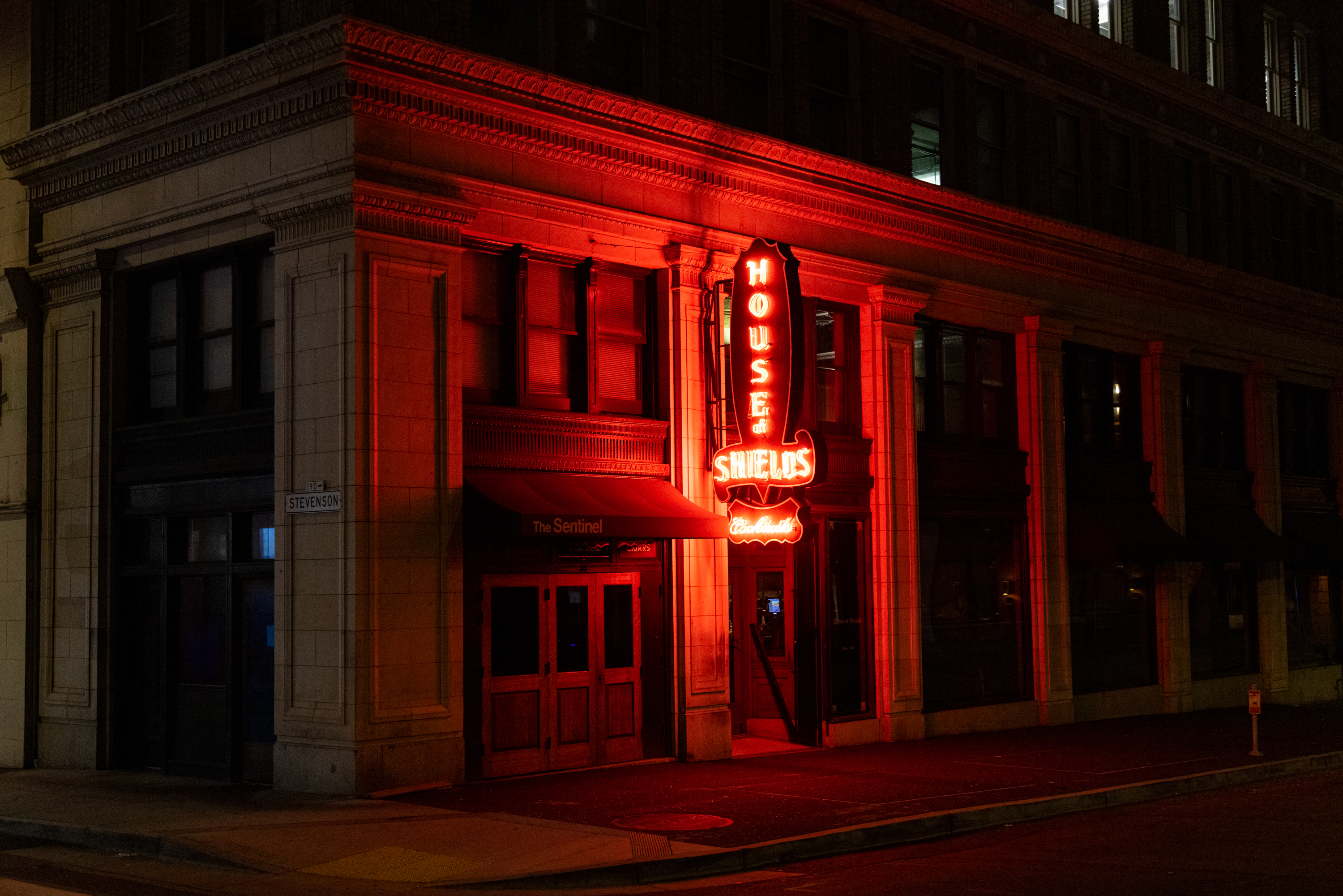 A red neon sign at night that reads &quot;House of Shields&quot;
