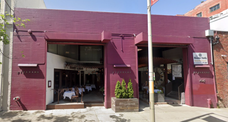 An eggplant-colored exterior of a restaurant with wide doors.