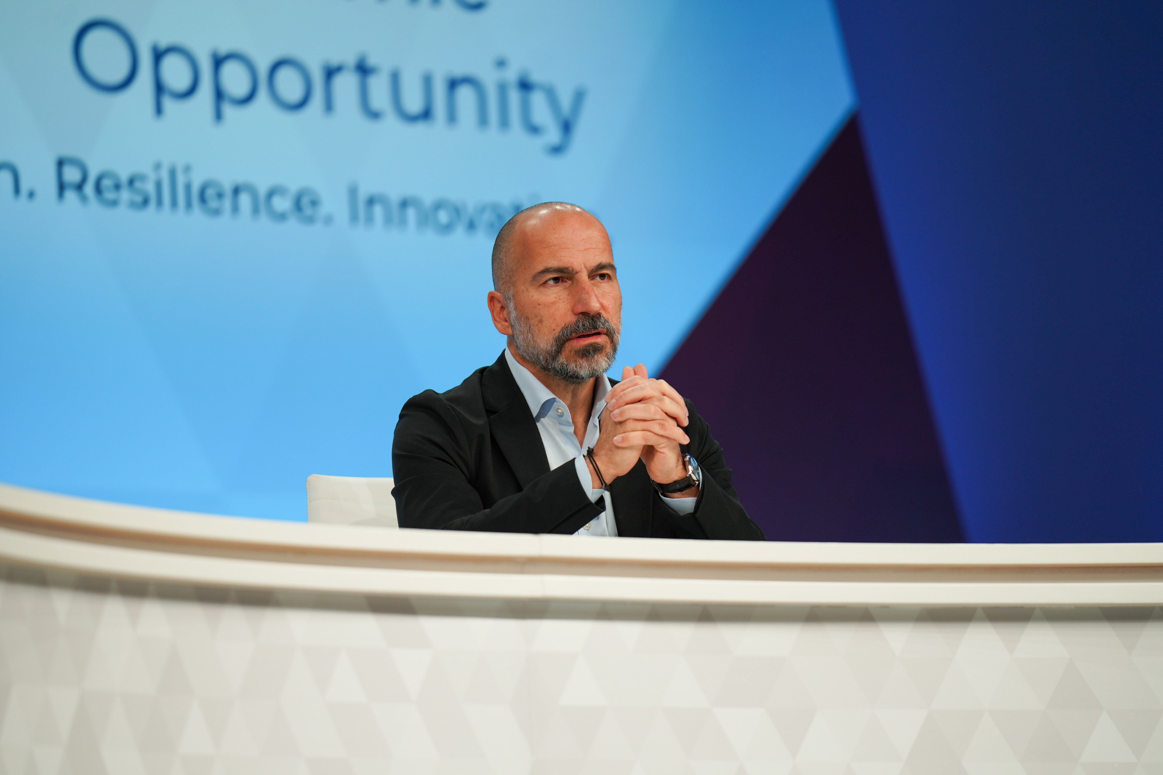 Uber CEO Dara Khosrowshahi is seated at a table while speaking at the APEC CEO Summit in San Francisco.