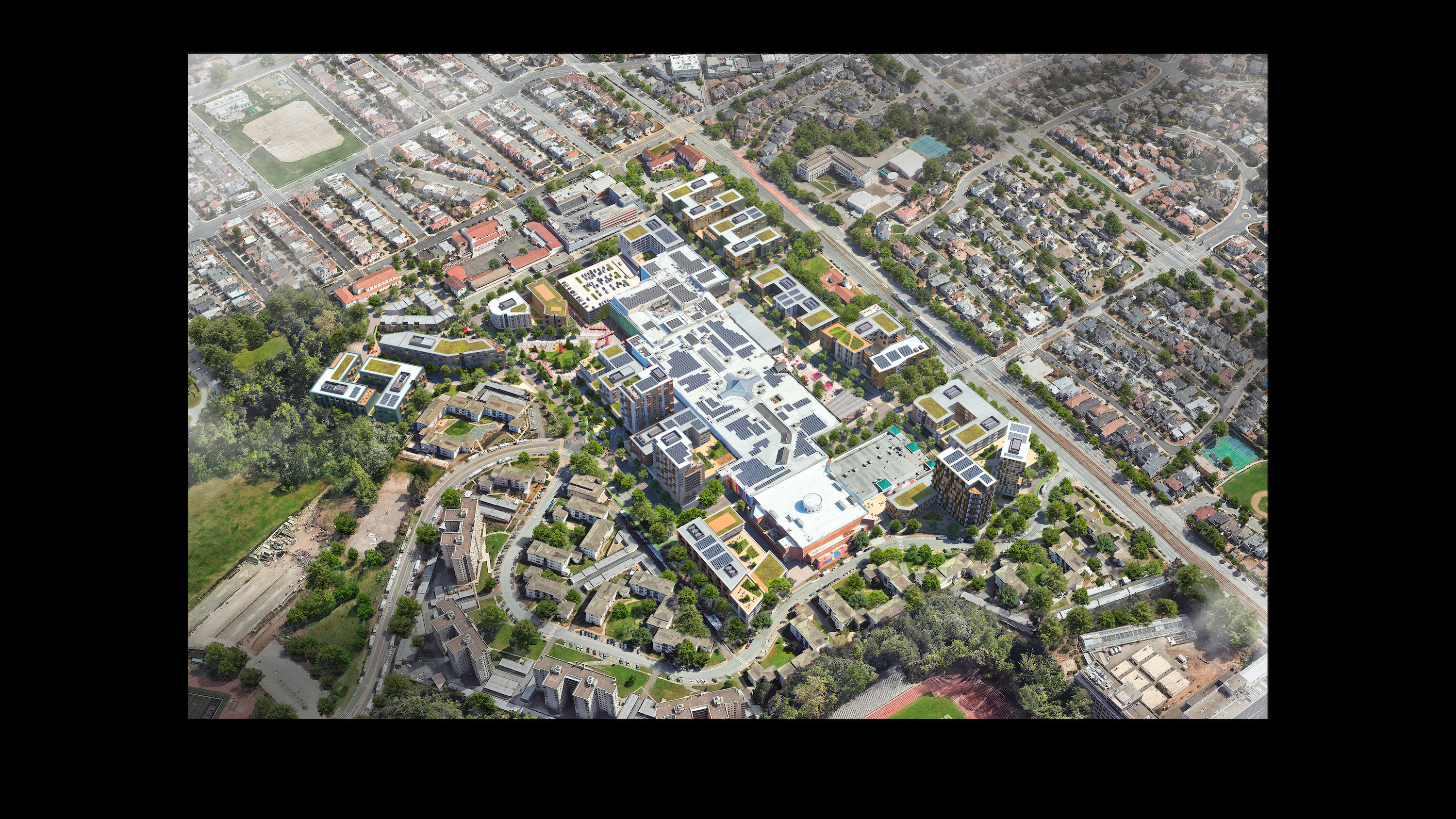 An aerial view of a housing development that could surround a mall with buildings, green space, parking and other amenities.