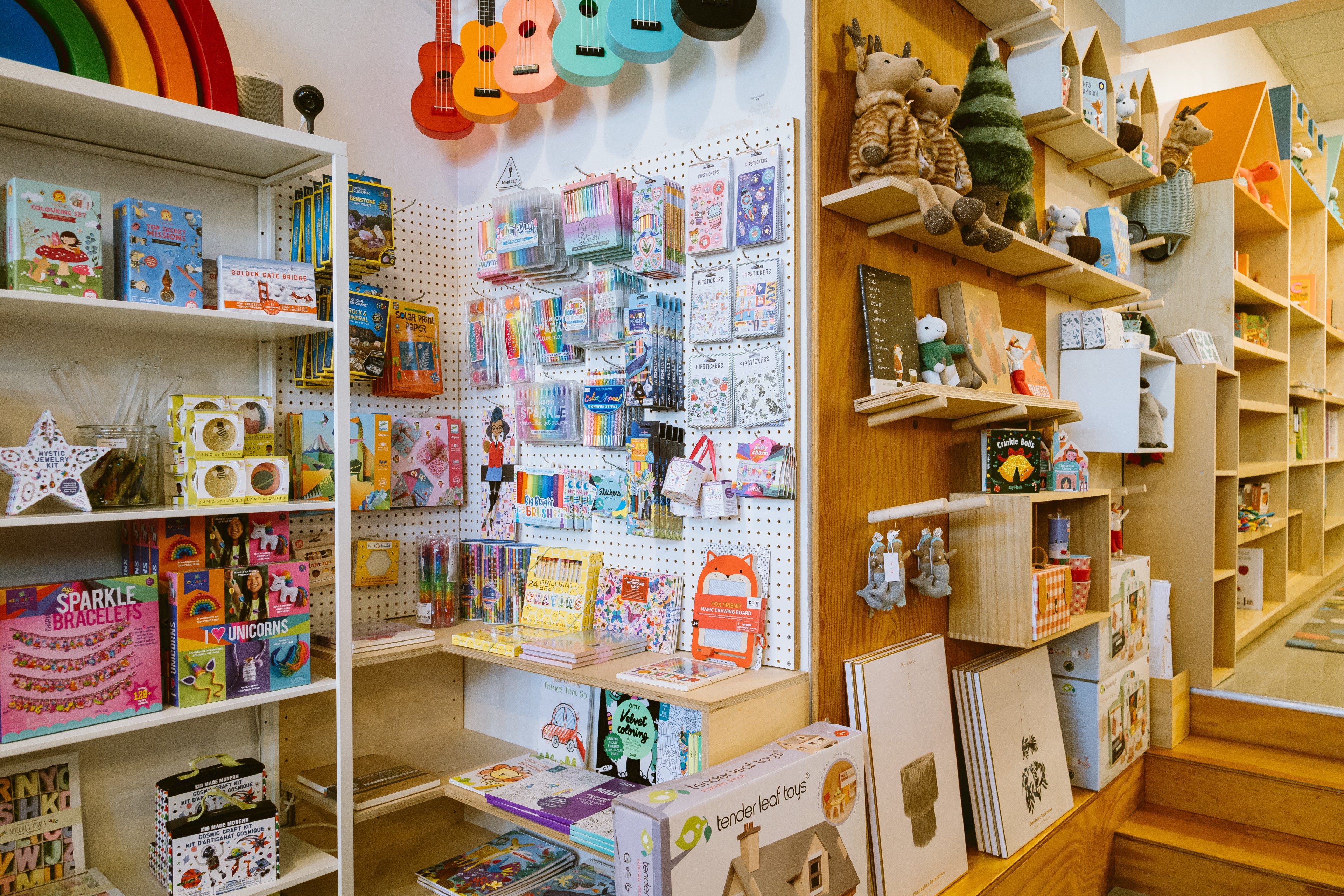 A selection of toys and games for kids including art supplies, guitars and stuffed animals.