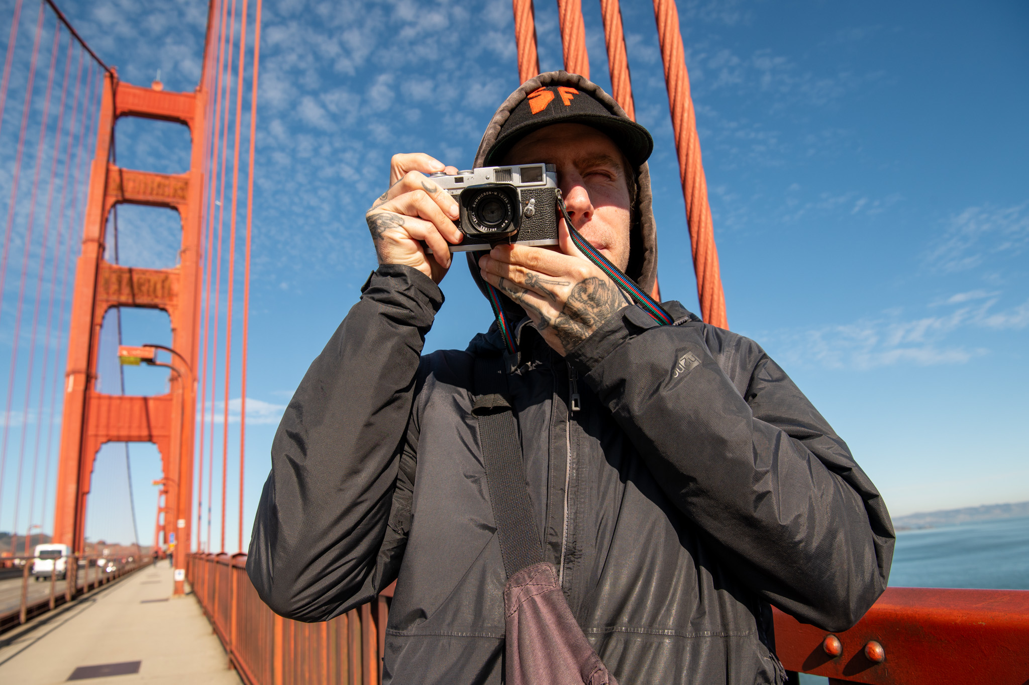 Jake Ricker looks through the viewfinder of his camera on the Golden Gate Bridge on Monday, Dec. 12, 2023. Ricker has been documenting the landmark through film photography for six years.'