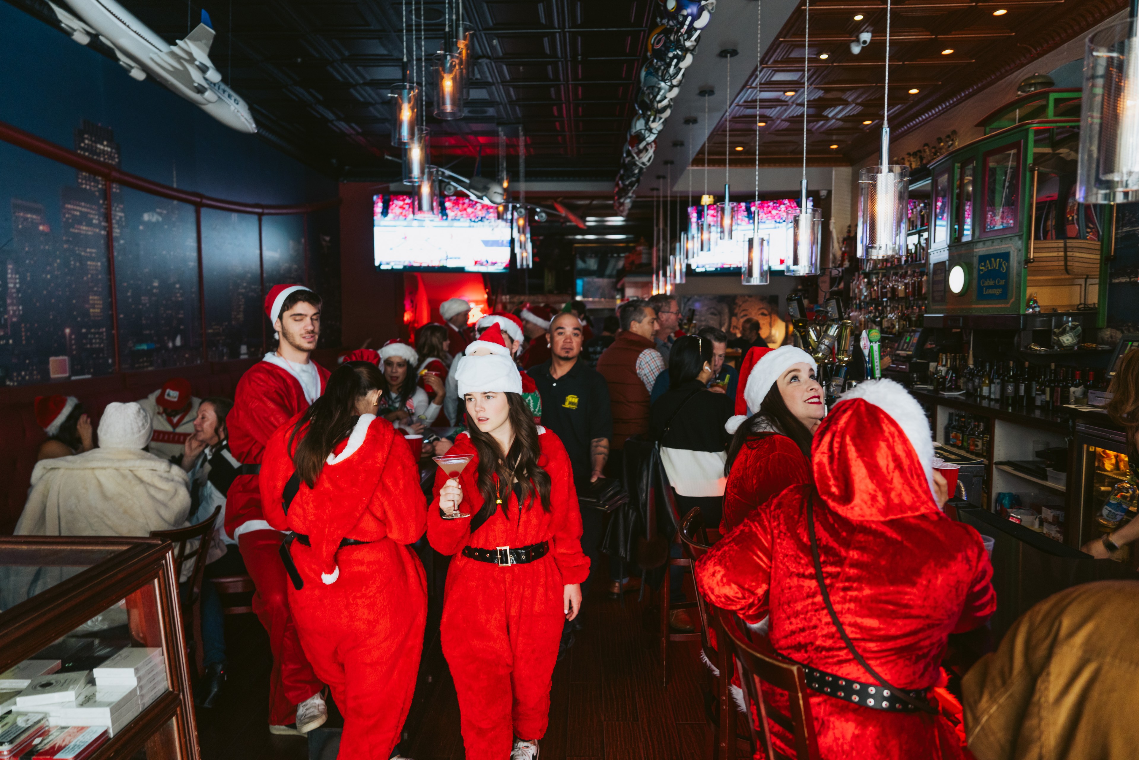 A bar full of patrons dressed as Santa Claus.