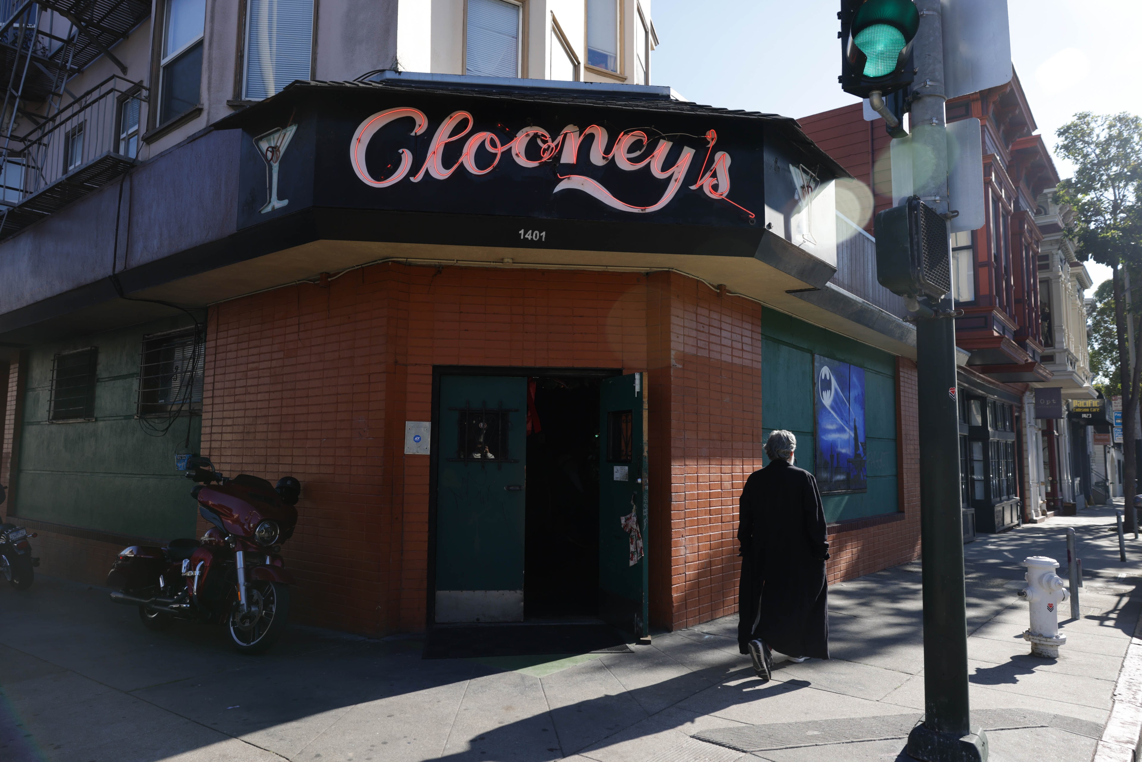 The front of a bar with a neon sign reading &quot;Clooney's&quot; sits on street corner.