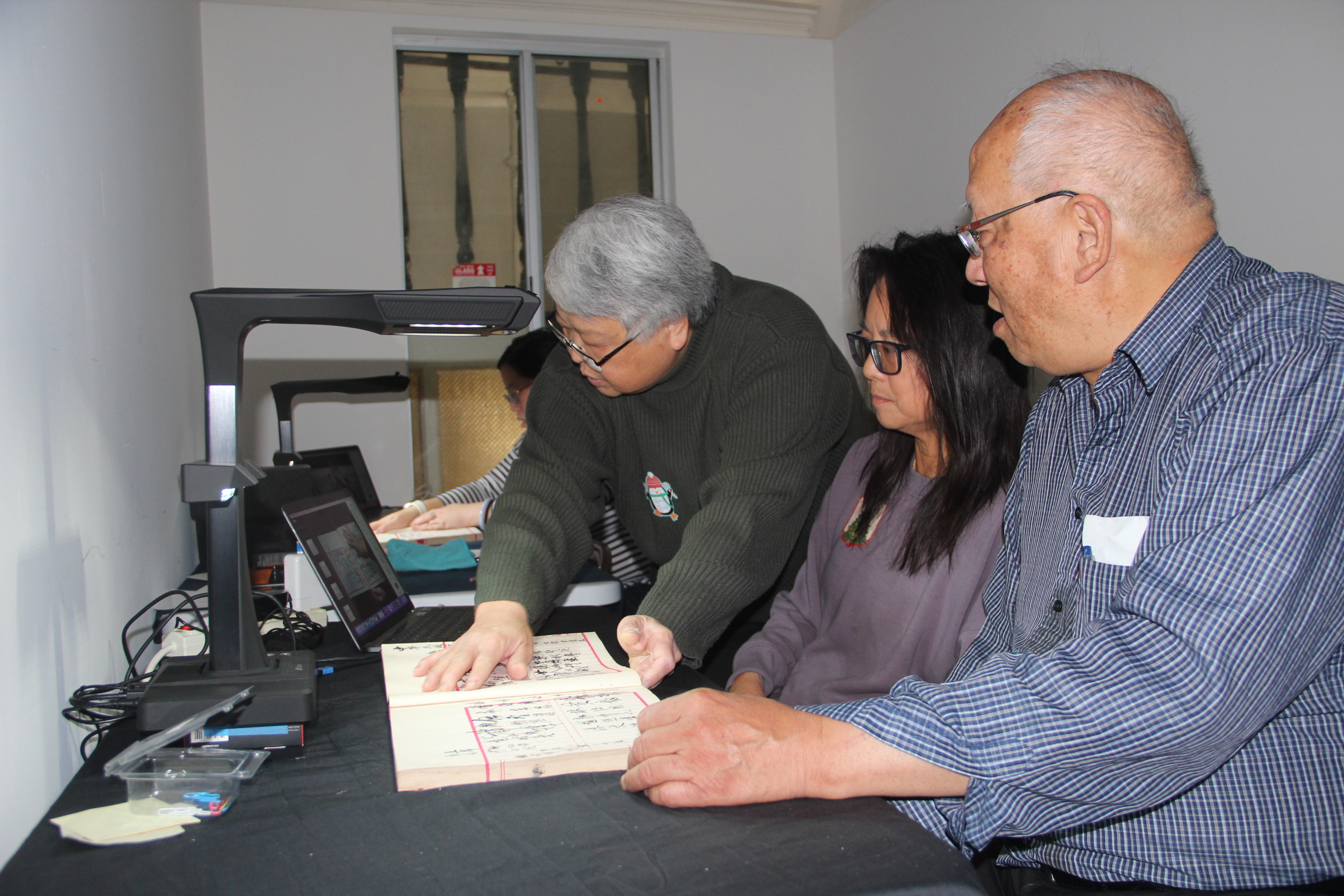 Volunteers help scan the document from the Chinese Consolidated Benevolent Association in San Francisco on December 21, 2023.
