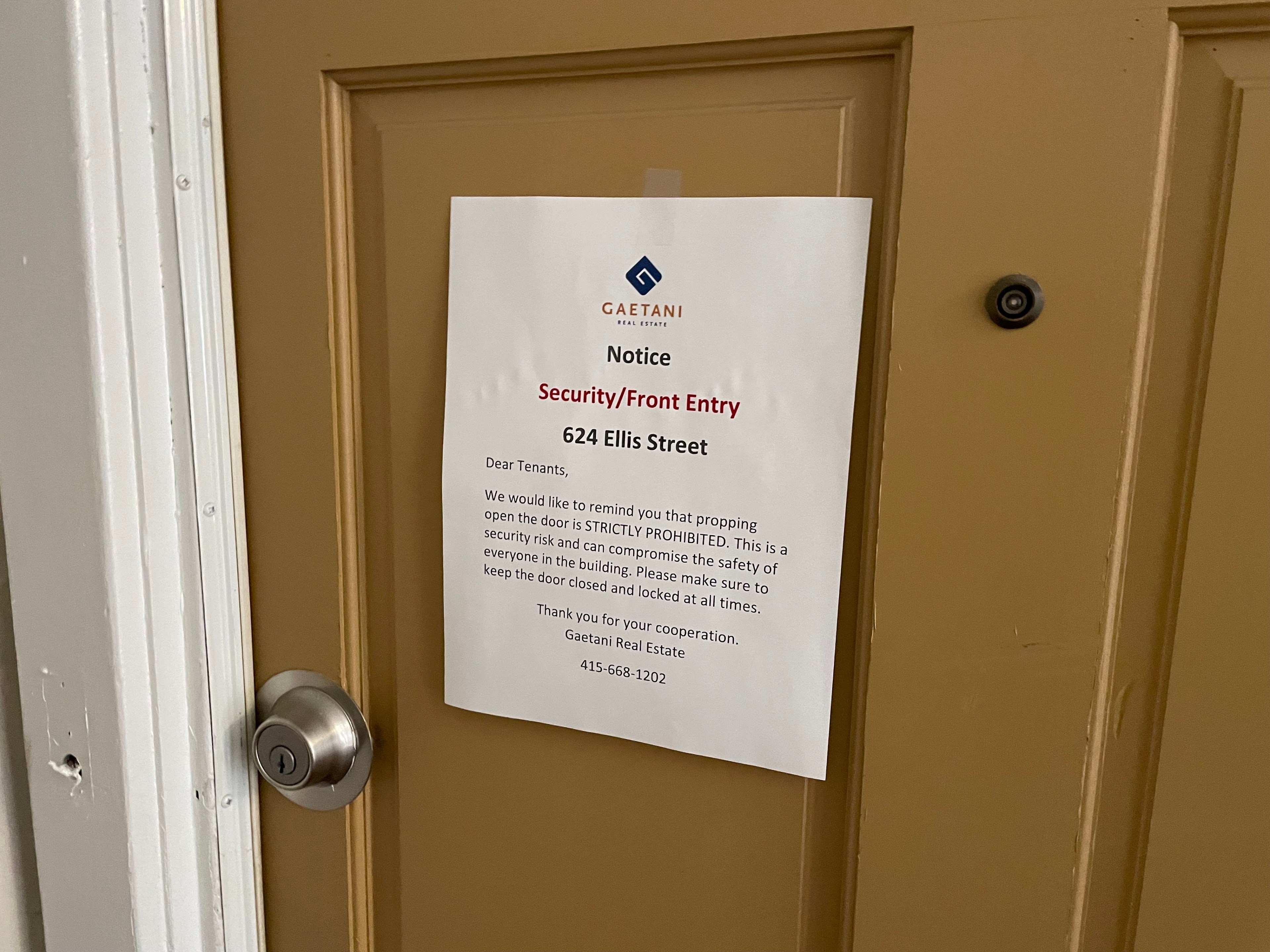 A sign posted on a hallway door warns building residents to not prop doors open to prevent non-residents from accessing the building.