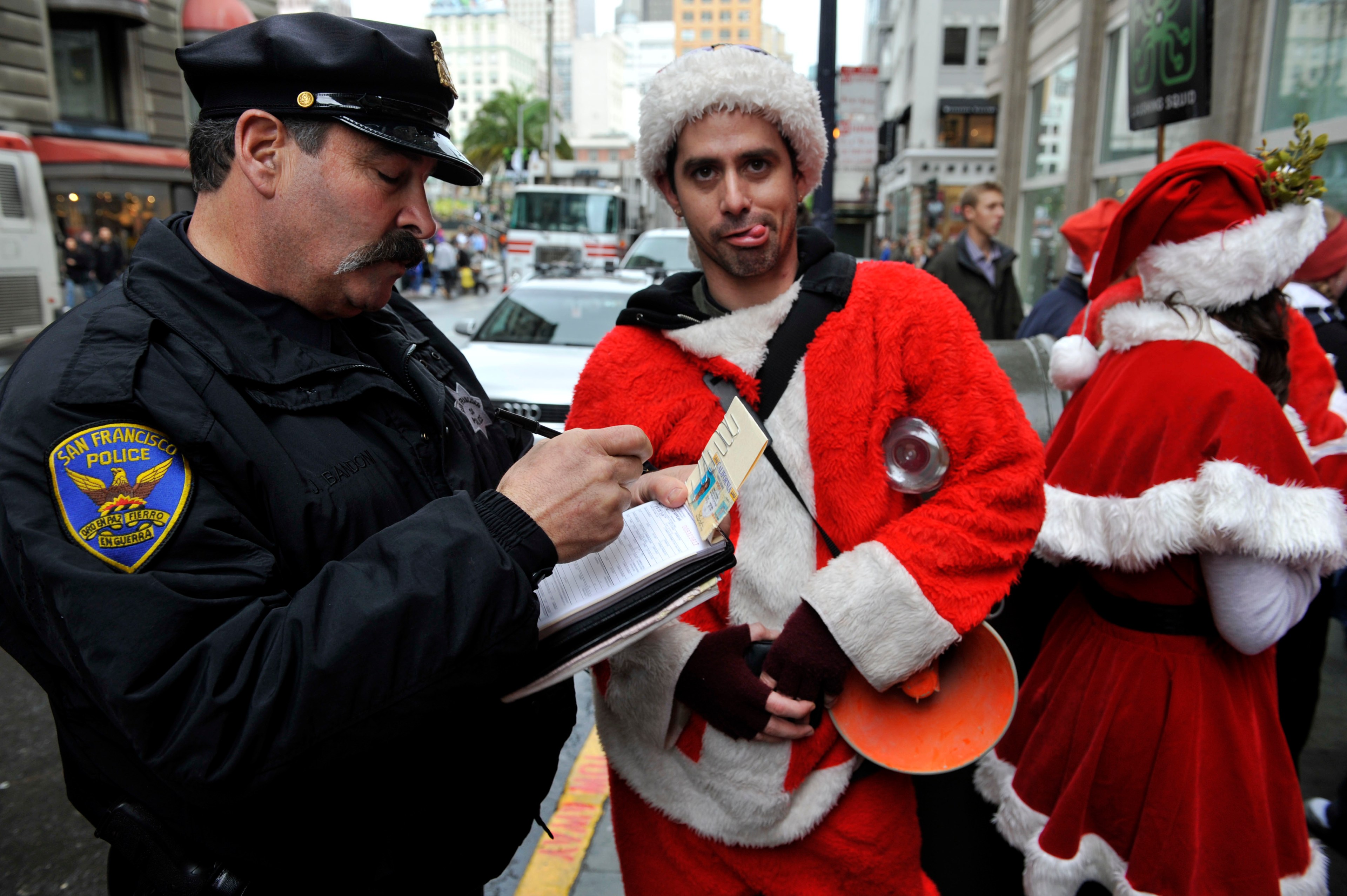 A Dec. 10, 2009 photo showing a San Francisco Police officer giving a man dressed as Santa Claus an open container ticket during the Santacon pub crawl in Downtown San Francisco. | Russel A. Daniels/AP Photo
