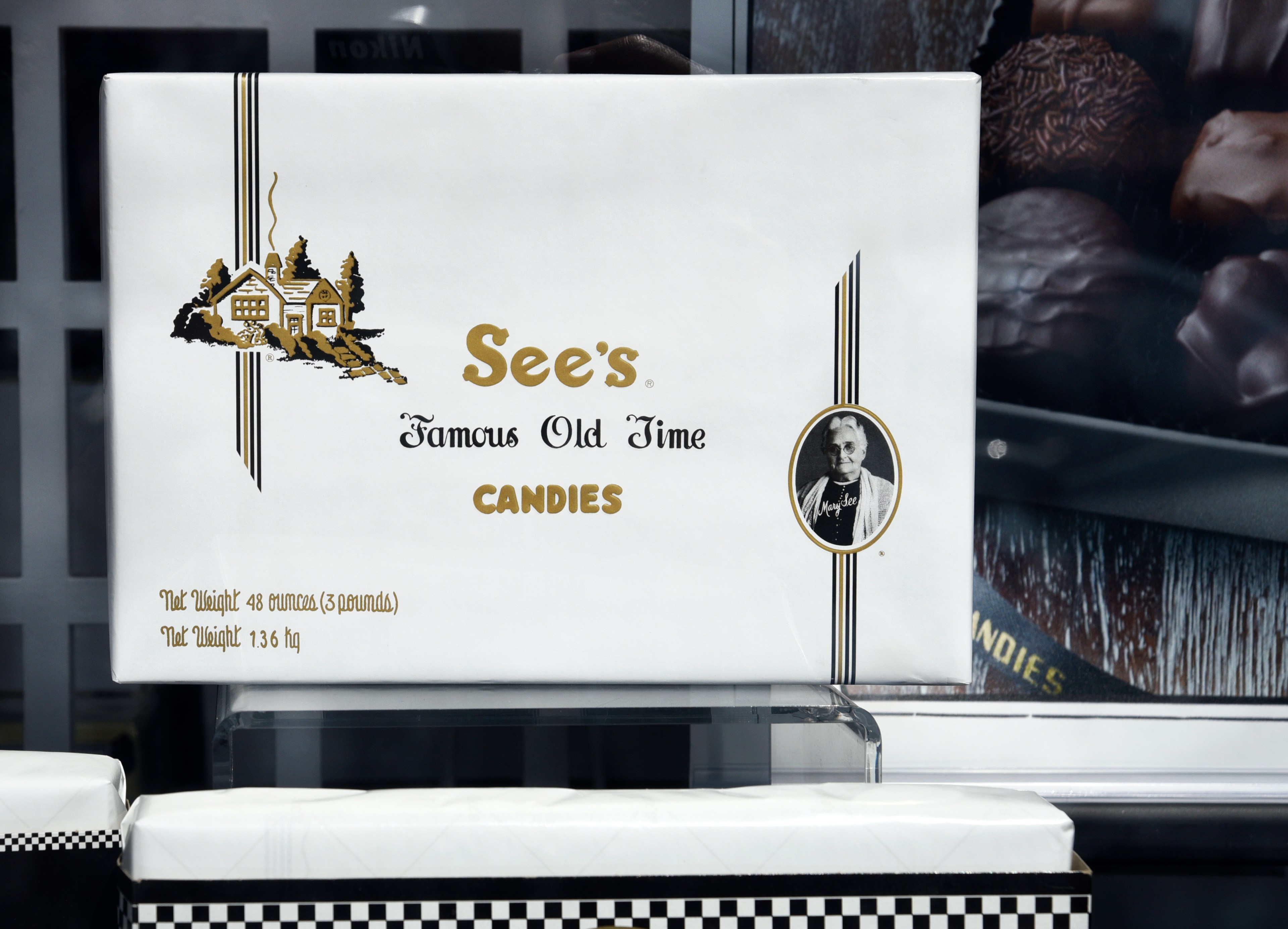 Box that says see's candies in a window