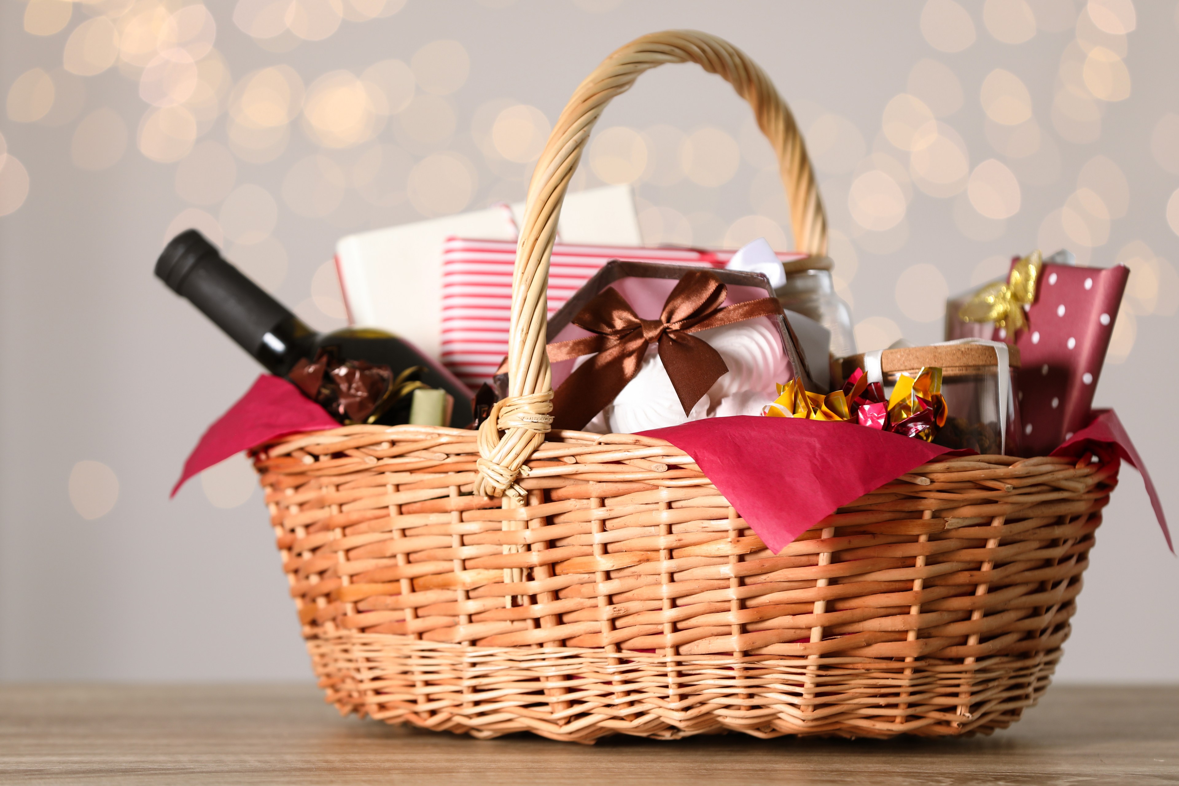 A wicker basket holds holiday items like wine and chocolates.