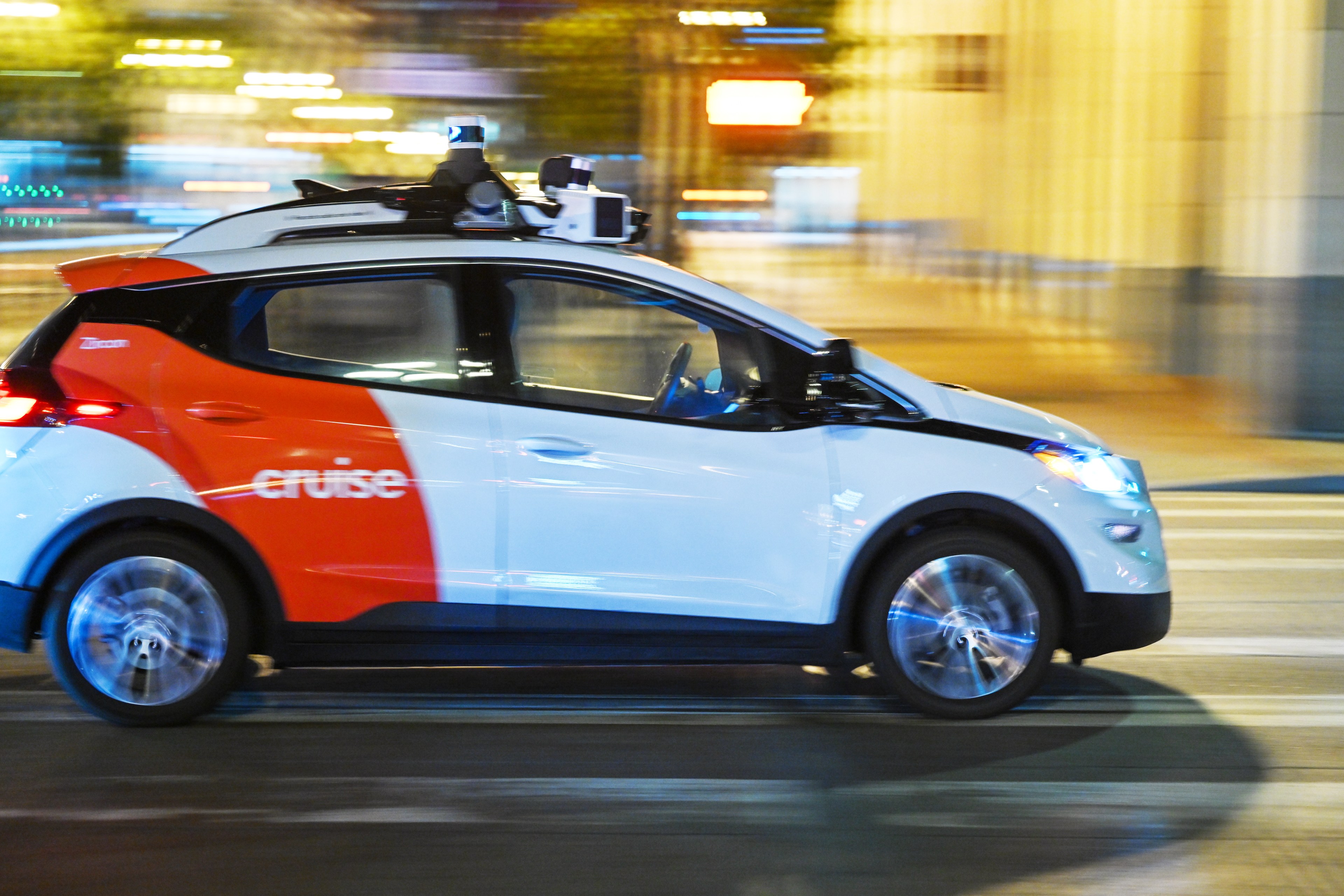 A Cruise vehicle, which is a driverless, autonomous robotaxi, drives at night in San Francisco.