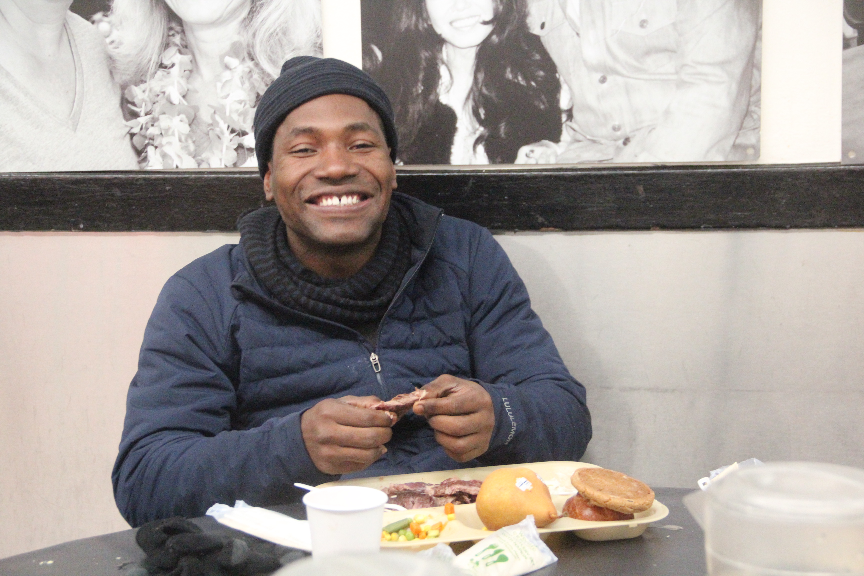 A man with a plate of food smiles.