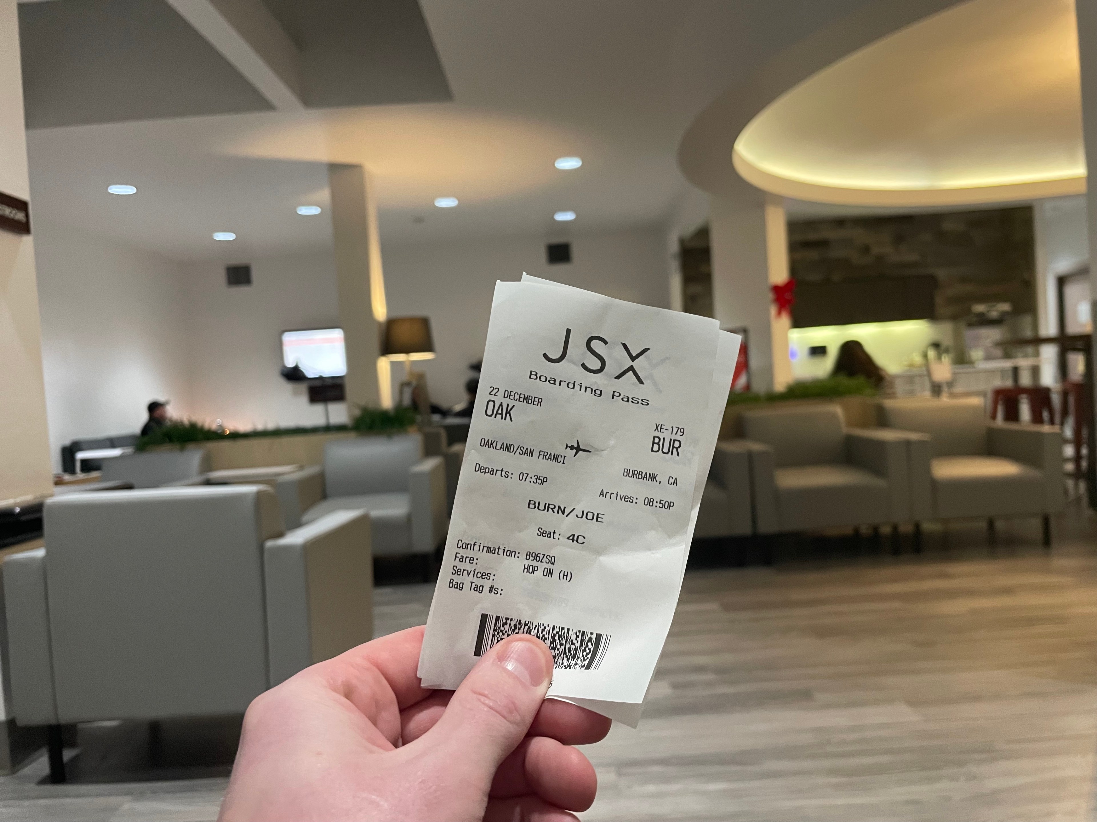 a man's hand holds a ticket to fly on a semi-private jet