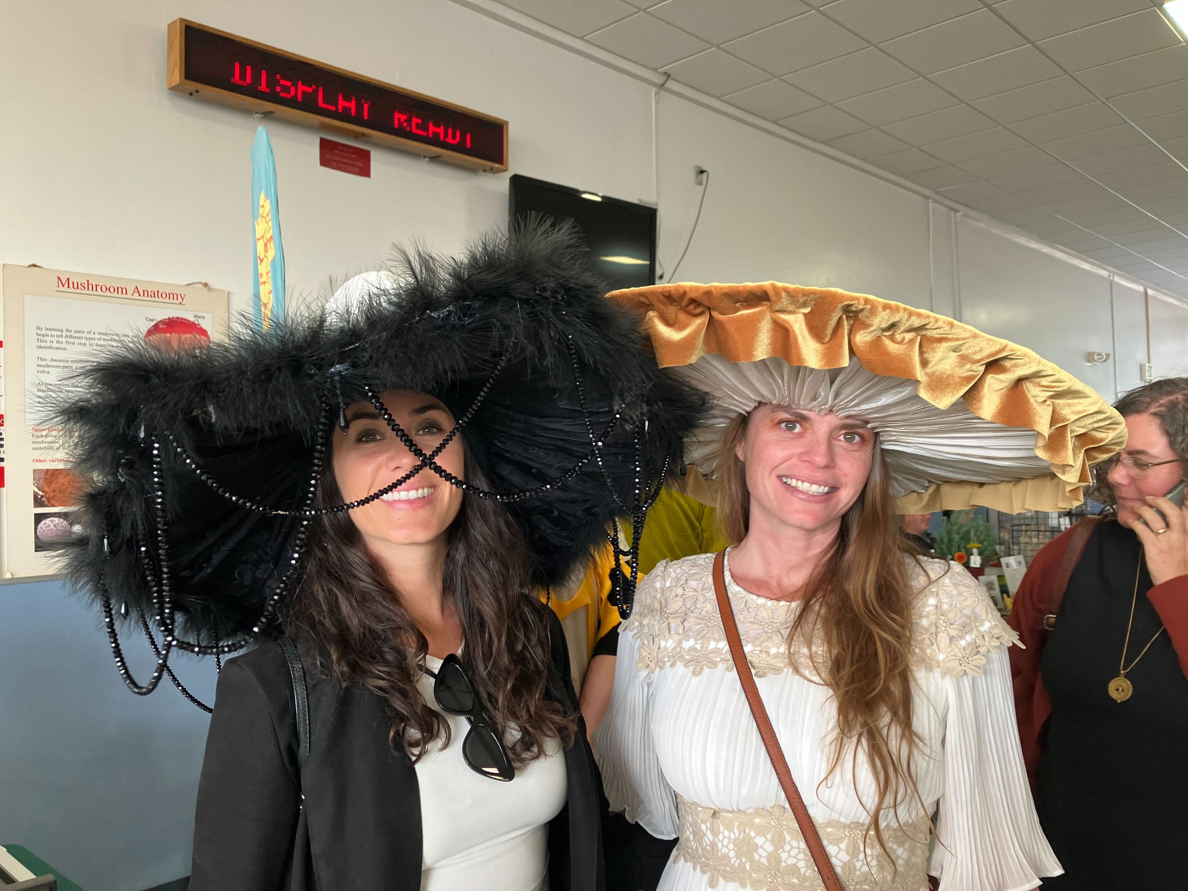 Ashley Gates and Bri Sturgess pose with their mushroom-inspired hats at the 51st annual Fungus Fair at El Camino High School in South San Francisco on Dec. 16, 2023.