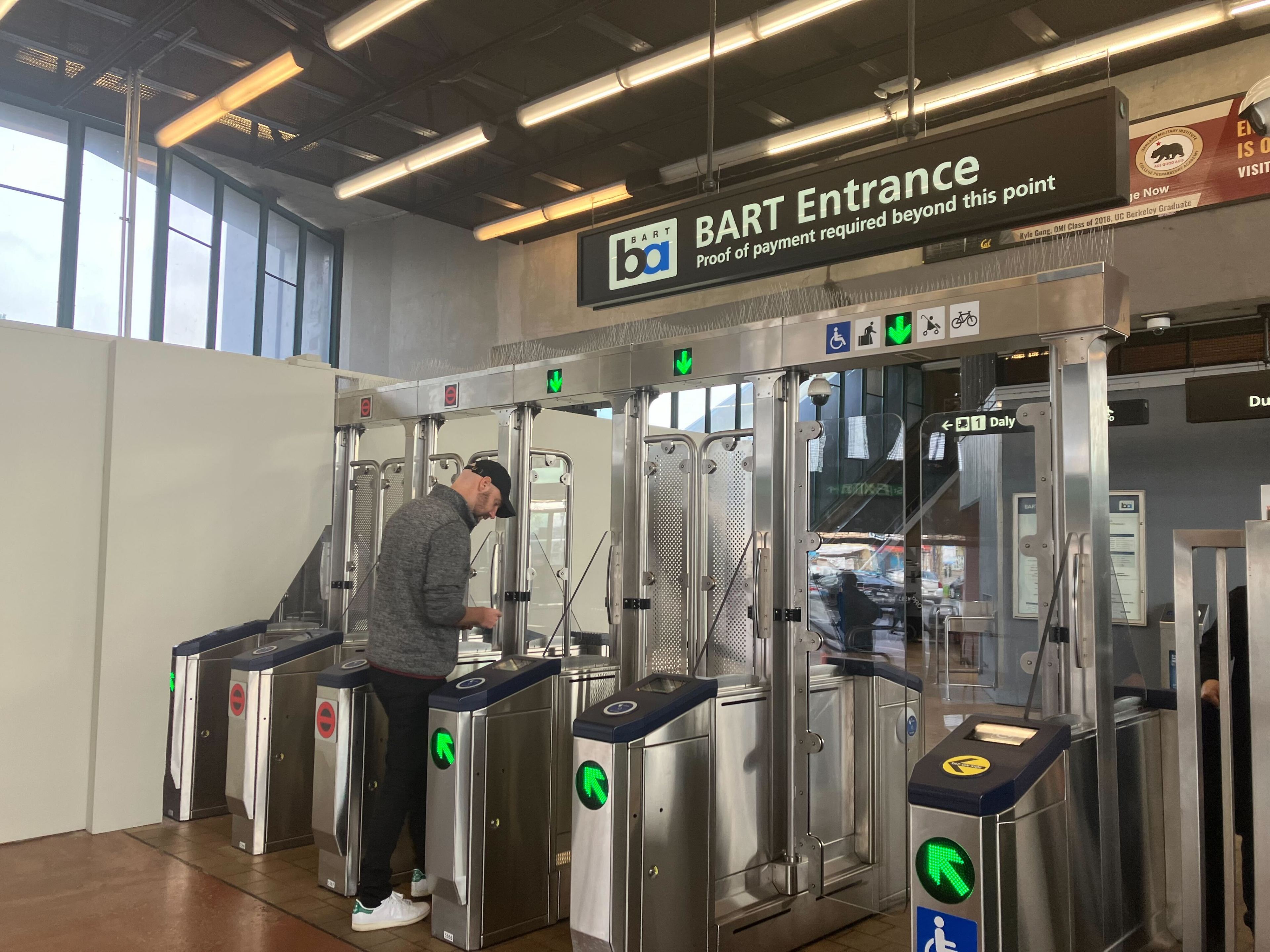 A rider scans his Clipper card at the new fare gates inside BART's West Oakland Station on Dec. 28, 2023.