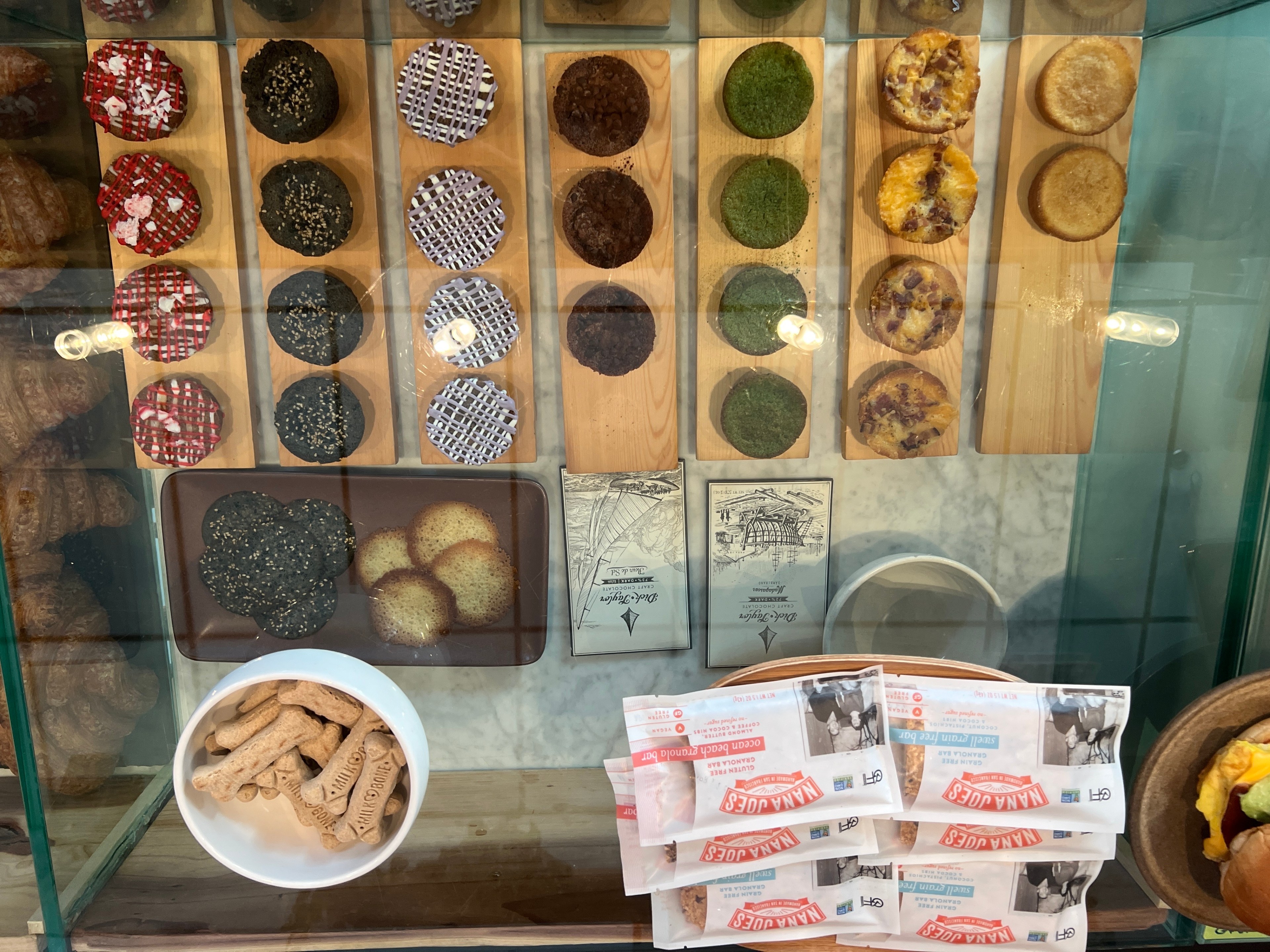 A view of a pastry case with multiple flavors of round cakes inside. 