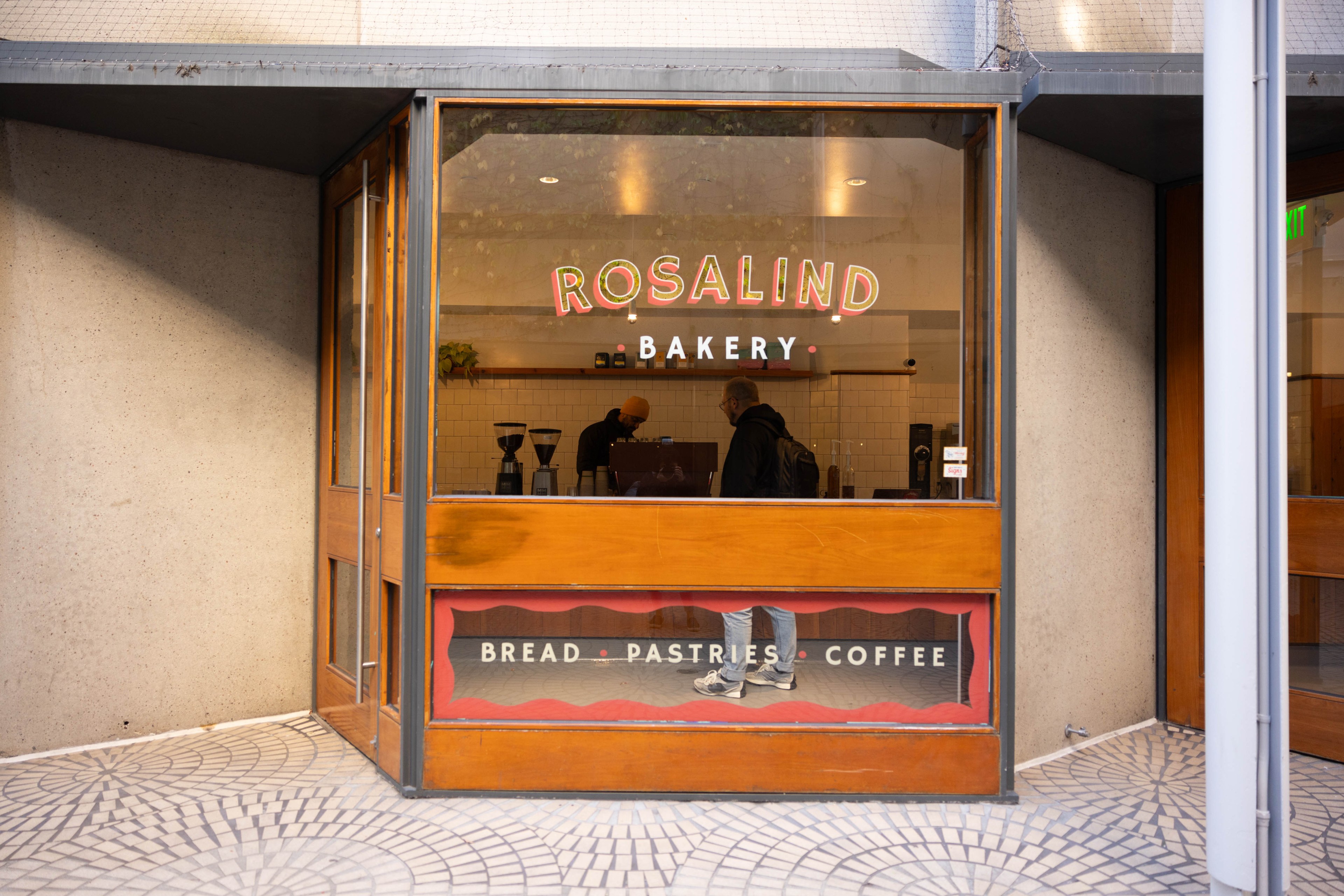 The exterior of a business with the words &quot;Rosalind Bakery, bread, pastries, coffee&quot; on the exterior