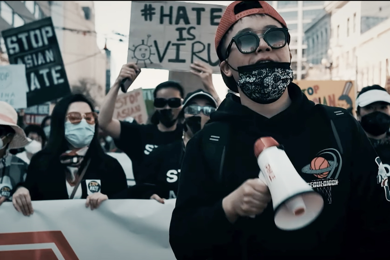 A man with a mace mask holds a bullhorn during a “Stop Asian Hate” demonstration.