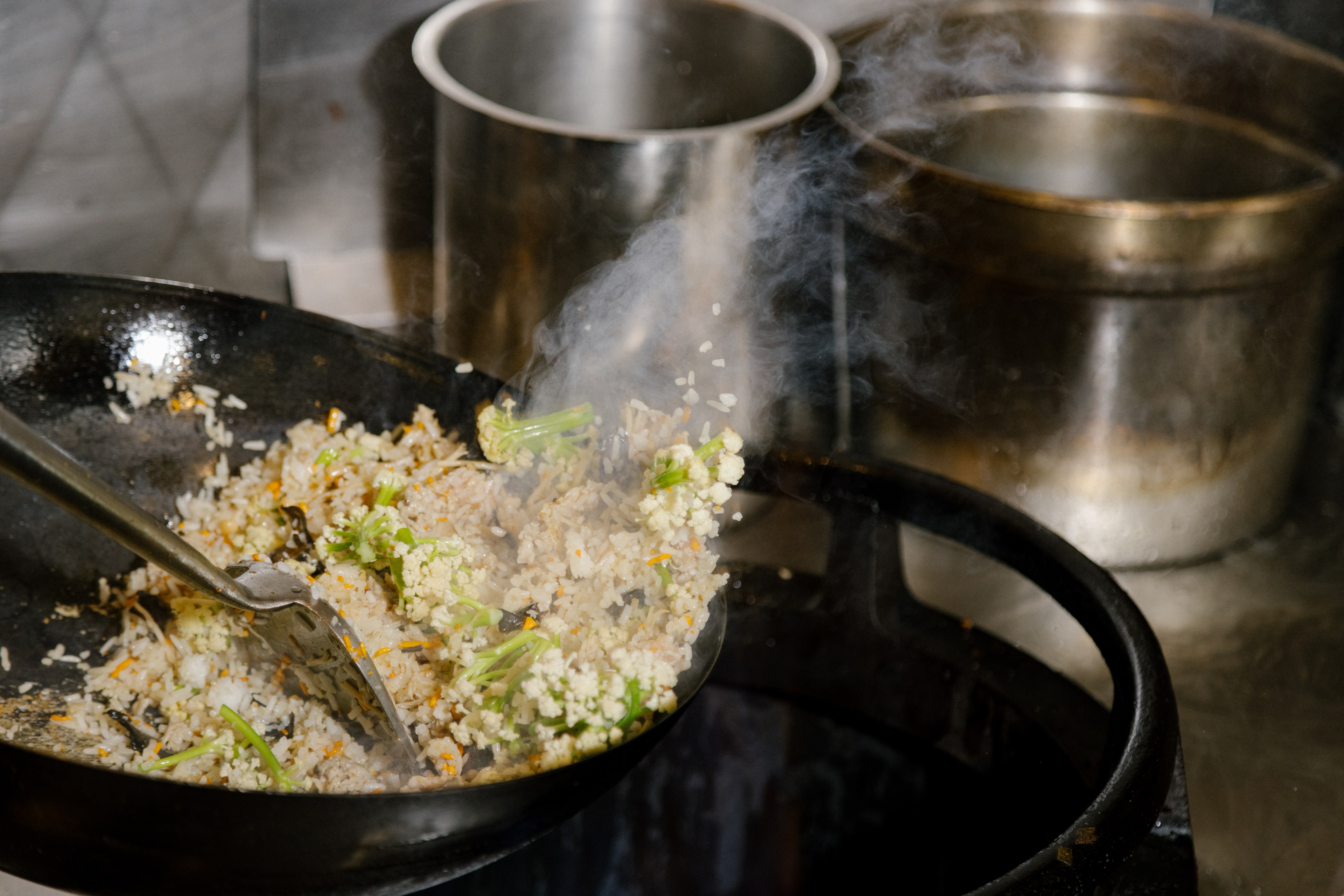 Chef Brandon Jew cooks fried rice in the kitchen at Mister Jiu’s.