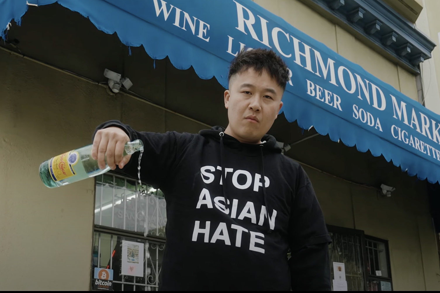 A man pours out liquor in front of Richmond Market.