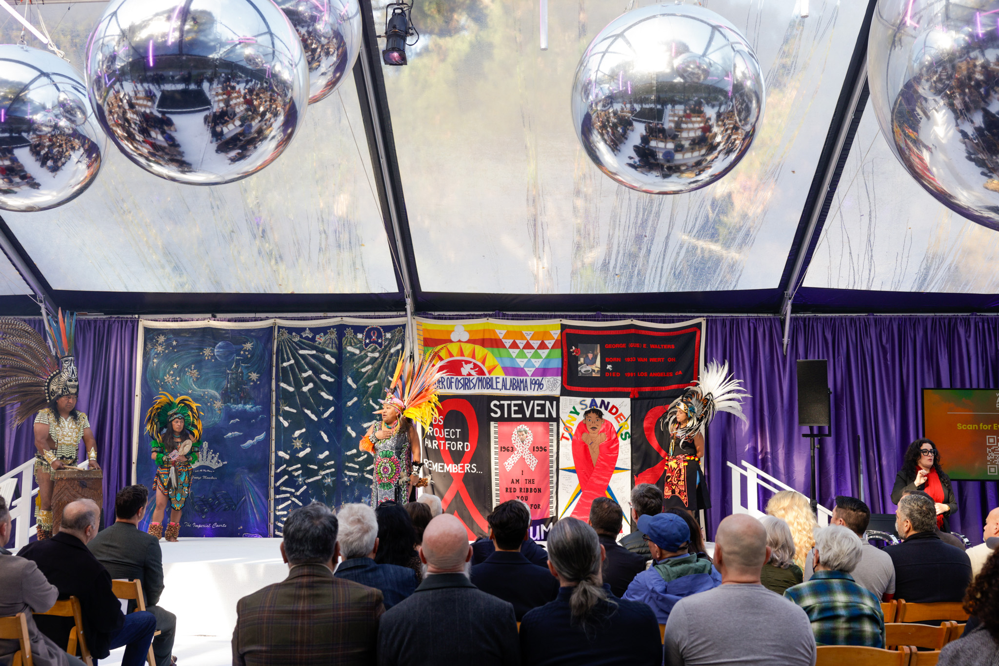 People sitting and watching Danza Azteca perform during World AIDS Day.