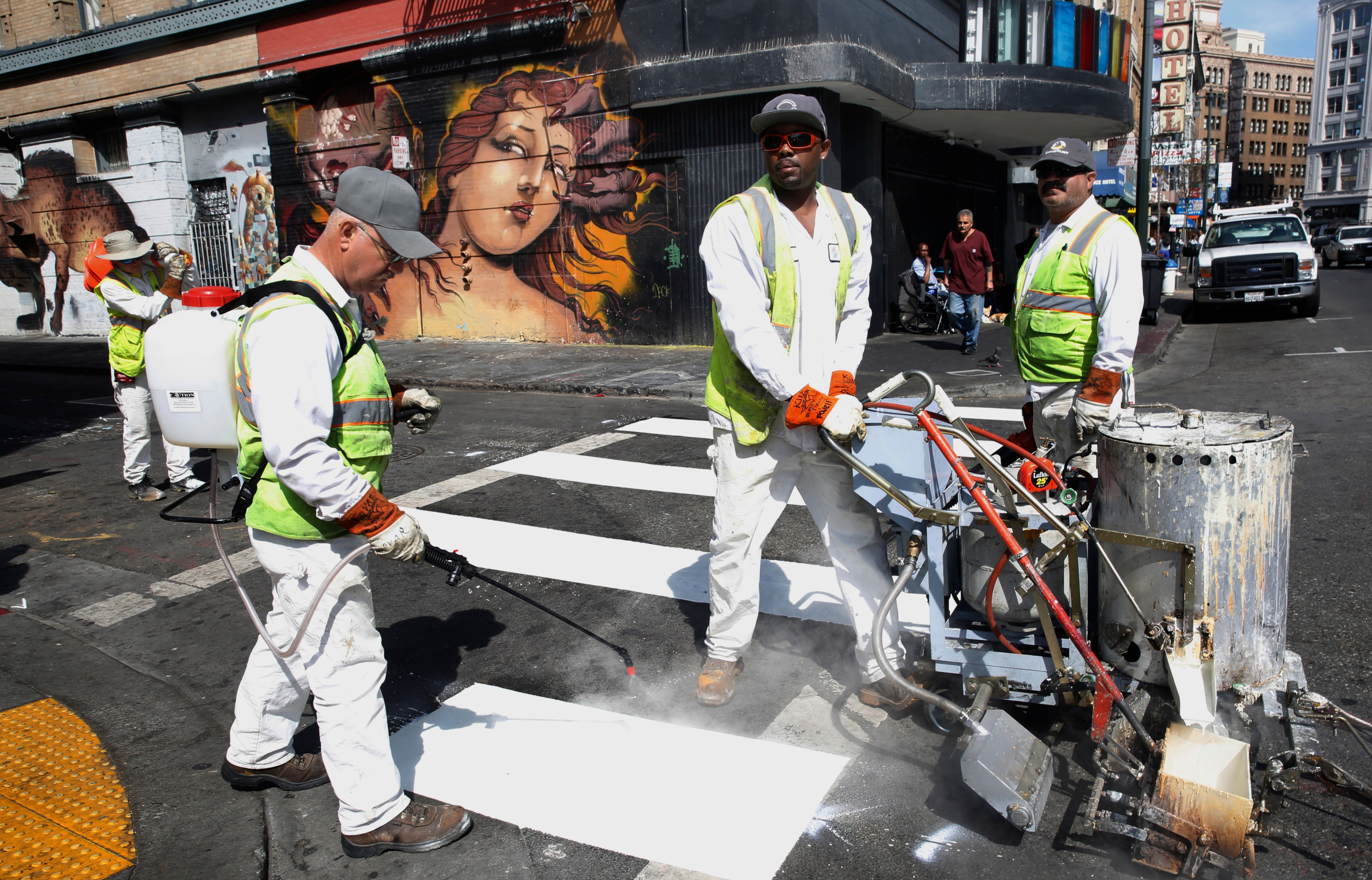 SFMTA workers painting stronger lines for pedestrian walkways on 6th Street at Stevenson.