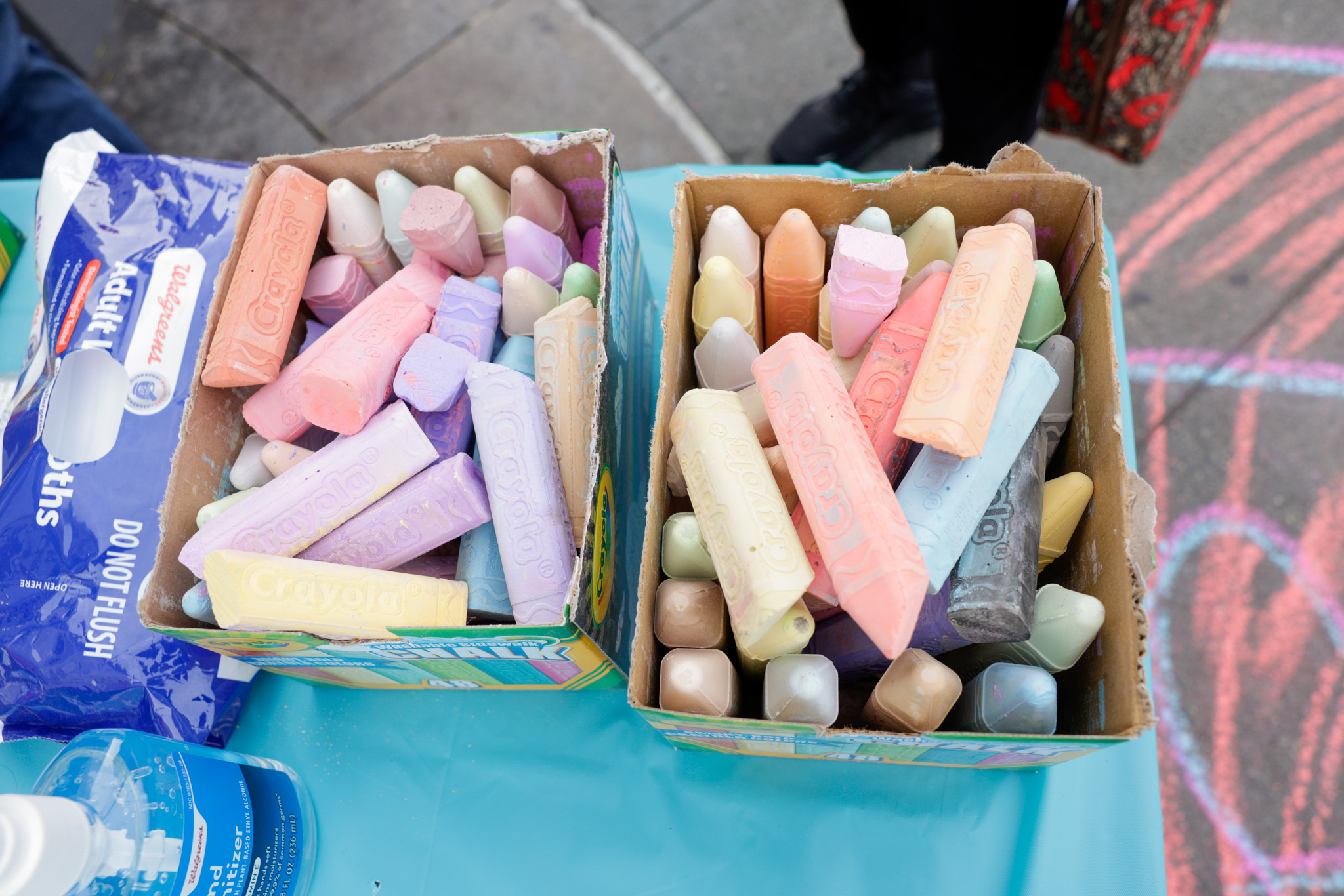 A box full of different color chalk that has been used to write peoples names down on the side walk during World AIDS Day.
