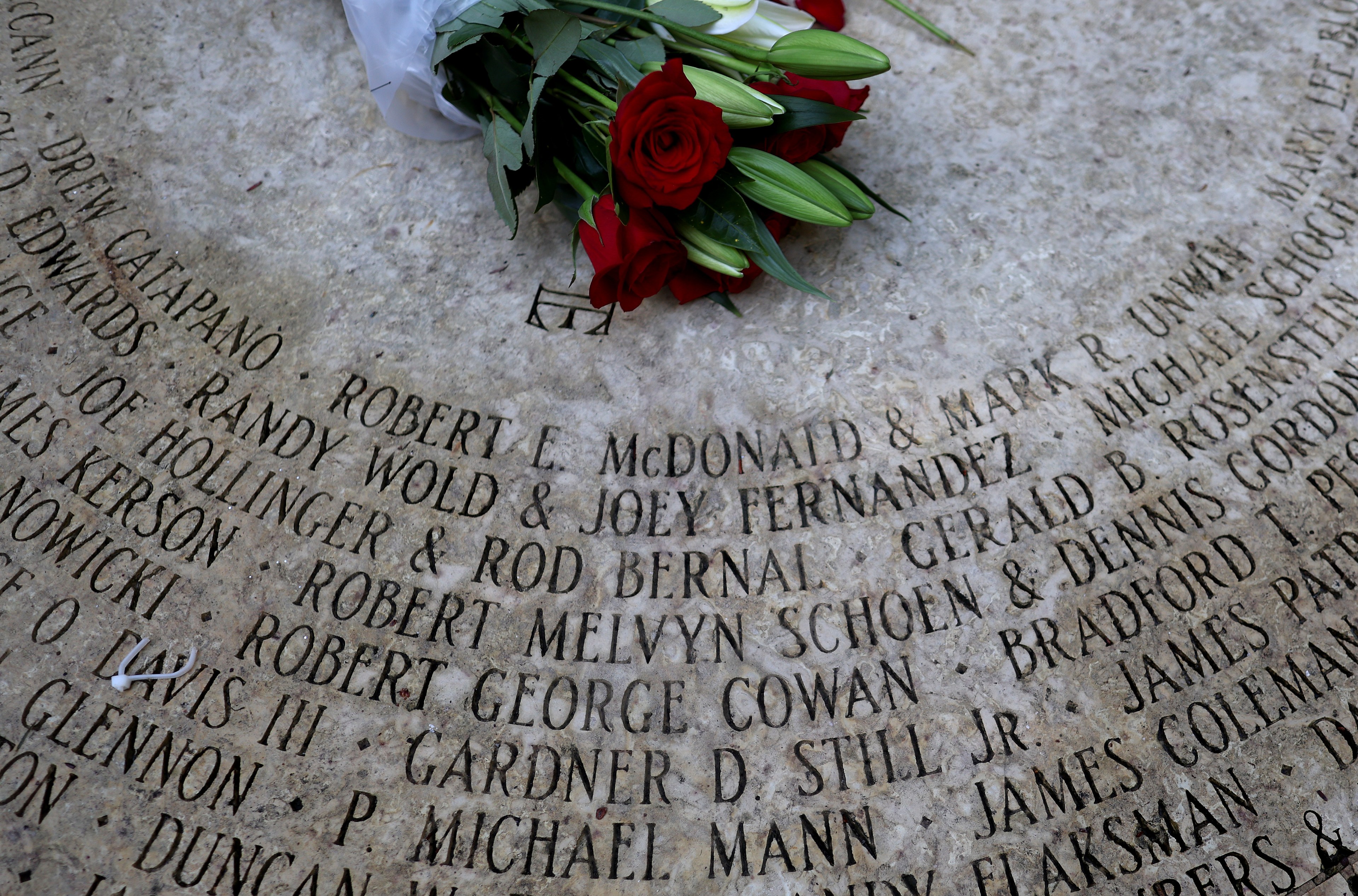 Rose ontop of names that are etched in marble who have passed because of AIDS.