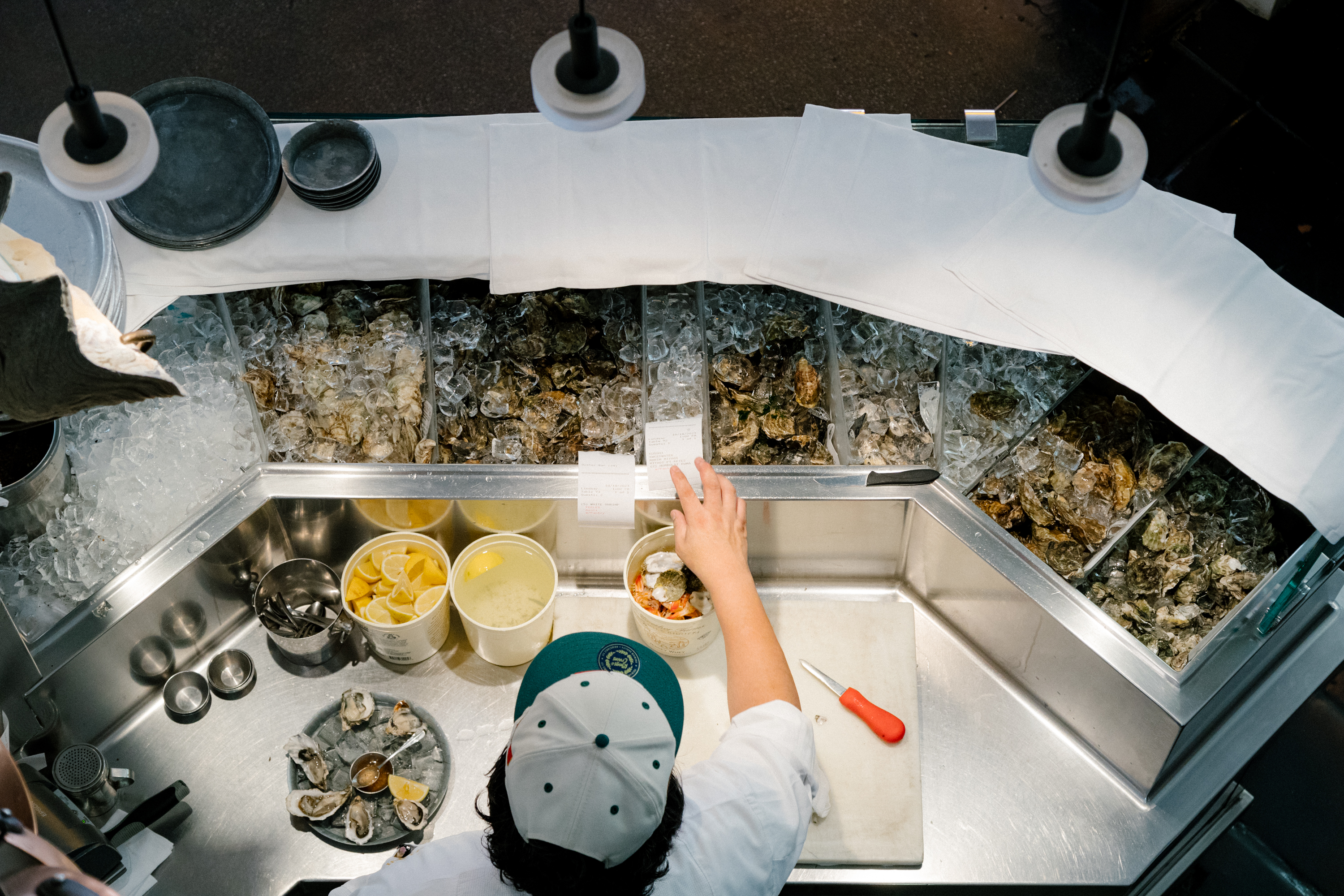 An over head view of a person taking orders at an oyster station.