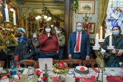 People with Mask inside the house that is decorated in Christmas theme.