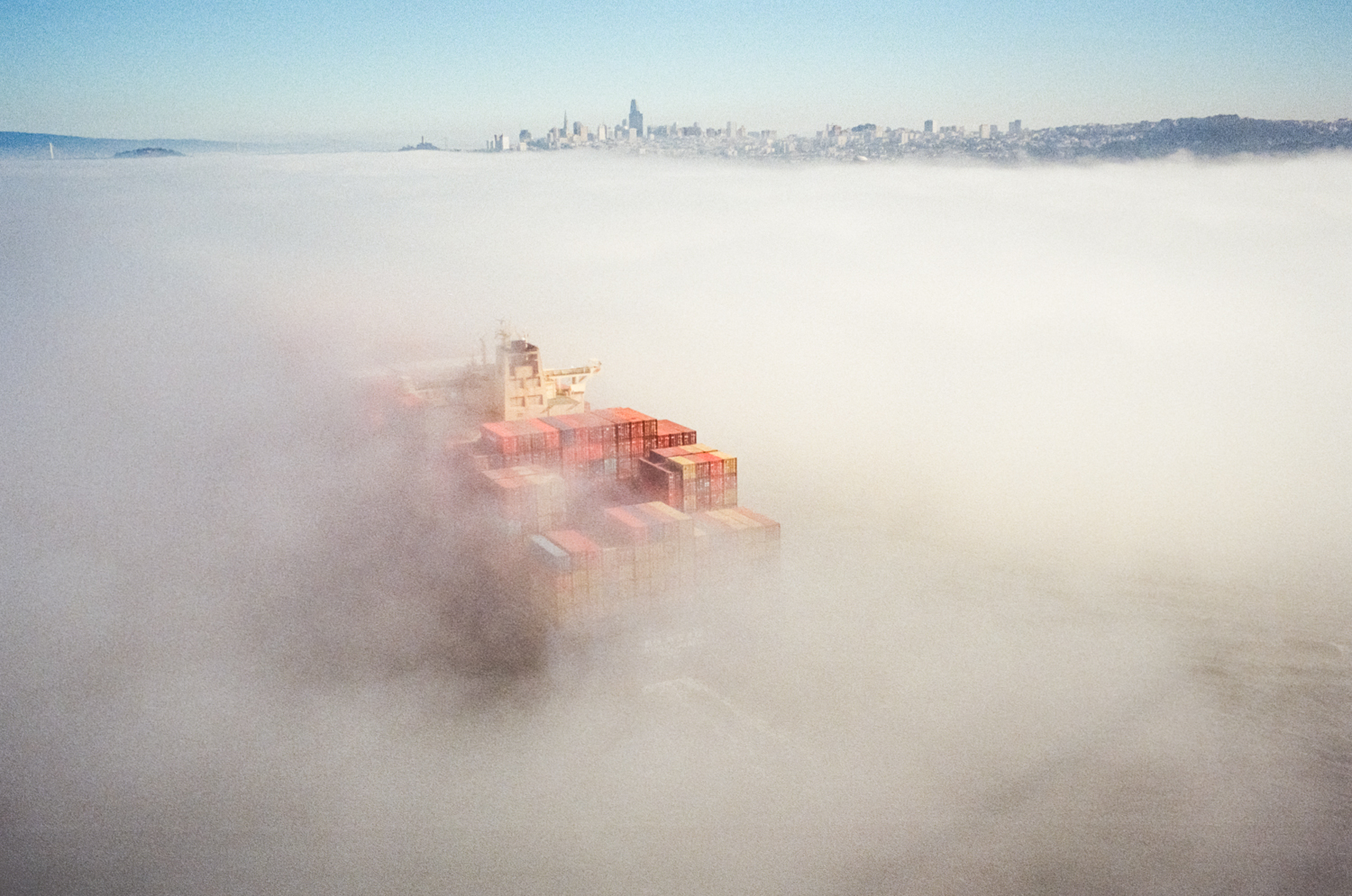 A container ship cuts through the low fog in June 2018.