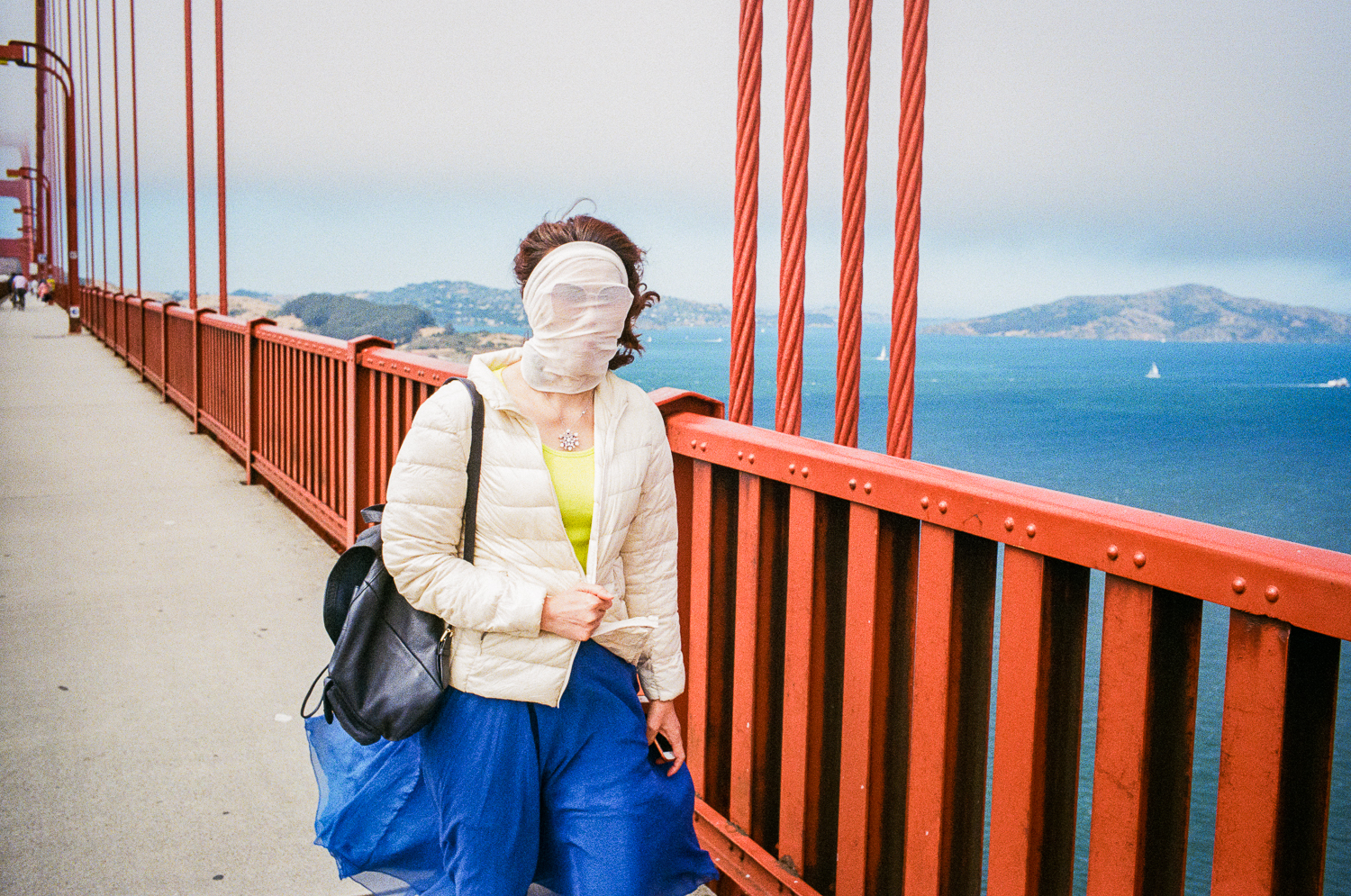 A woman walks over the bridge with a covering over her face in September 2019.