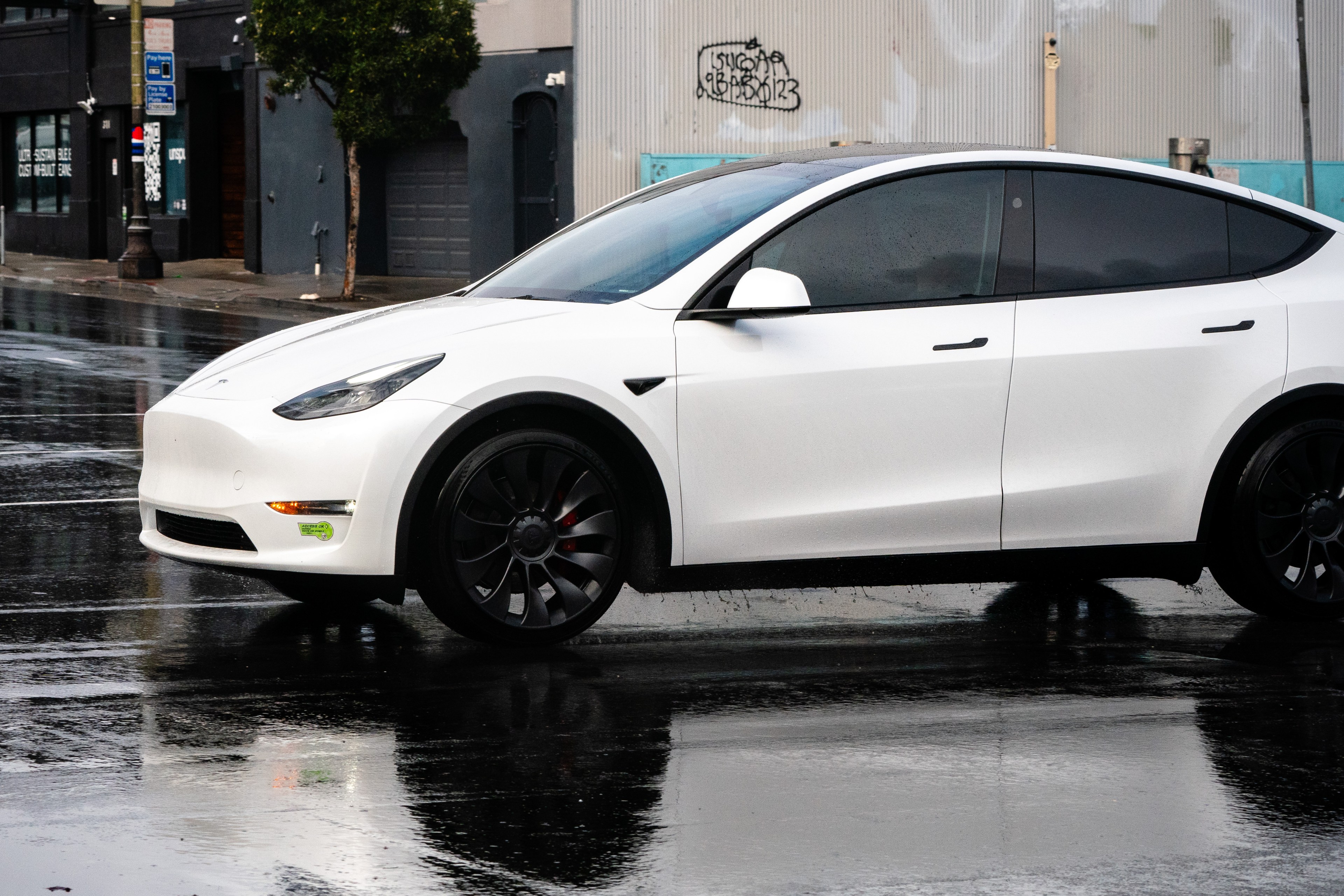 A white Tesla Model Y with no front license plate.
